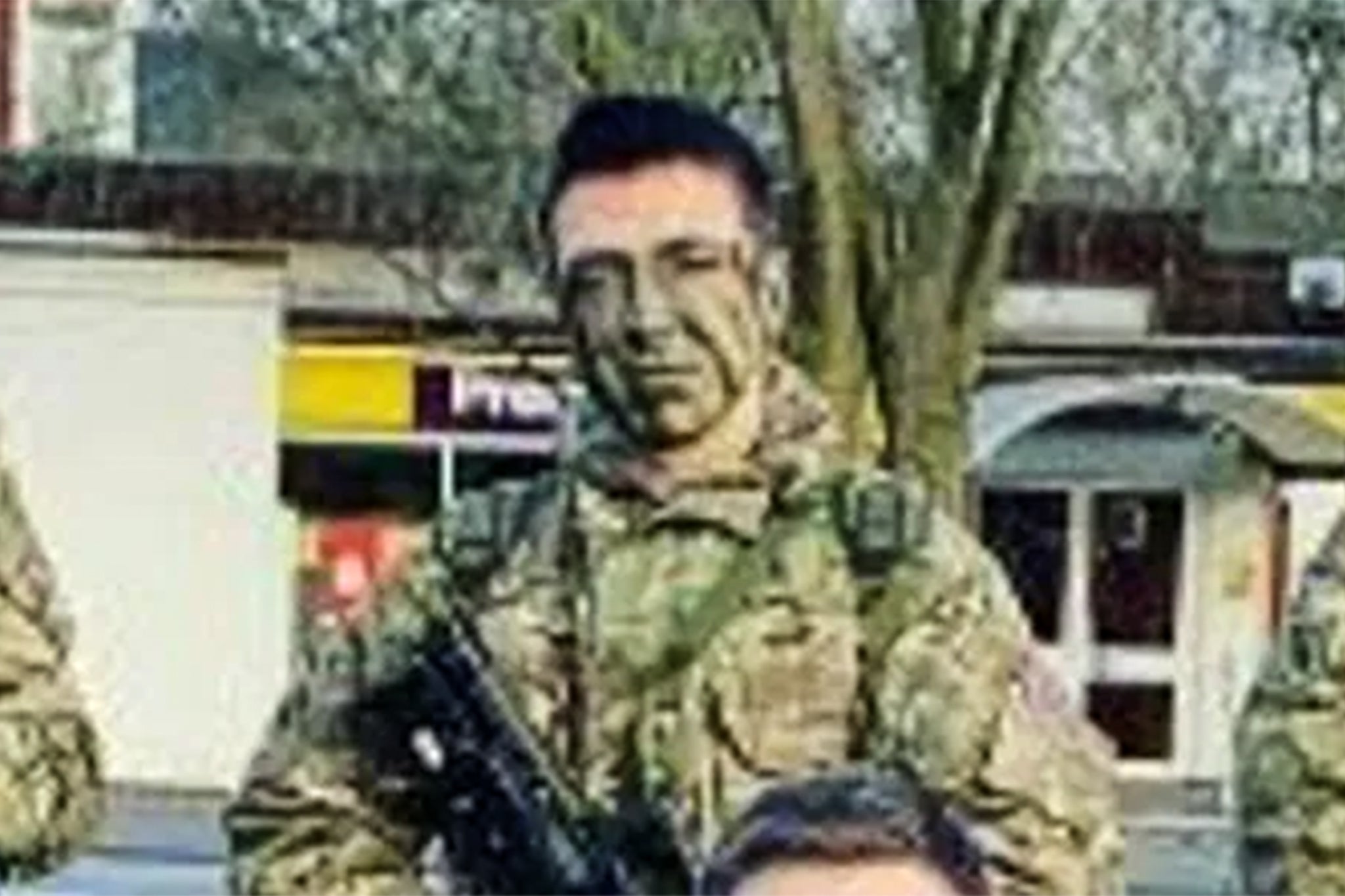 A picture of former soldier Kyle Clifford from his military career shows him dressed in army fatigues carrying a weapon, with camouflage paint on his face