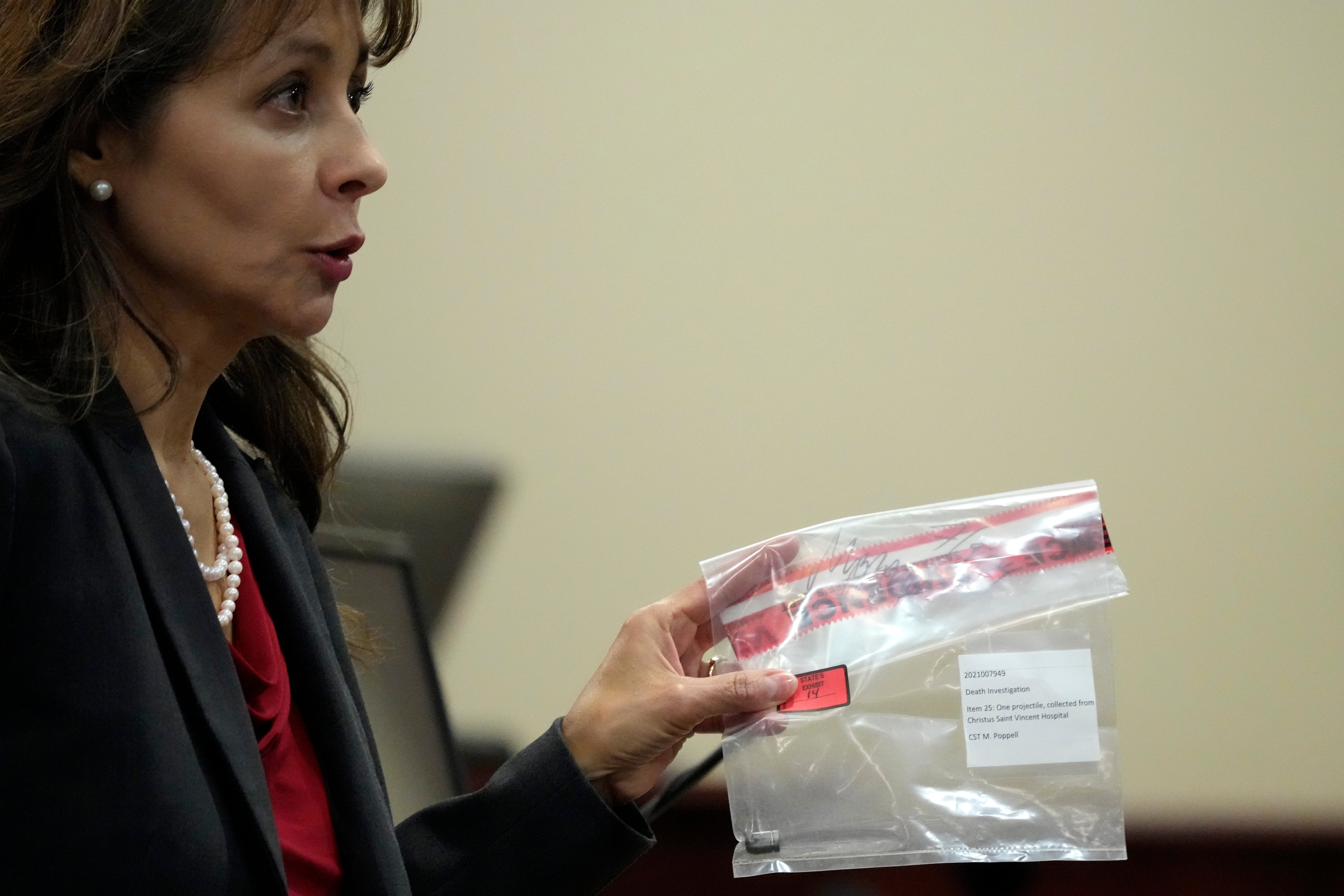 Special prosecutor Erlinda Ocampo Johnson shows a bullet in an evidence bag during the trial