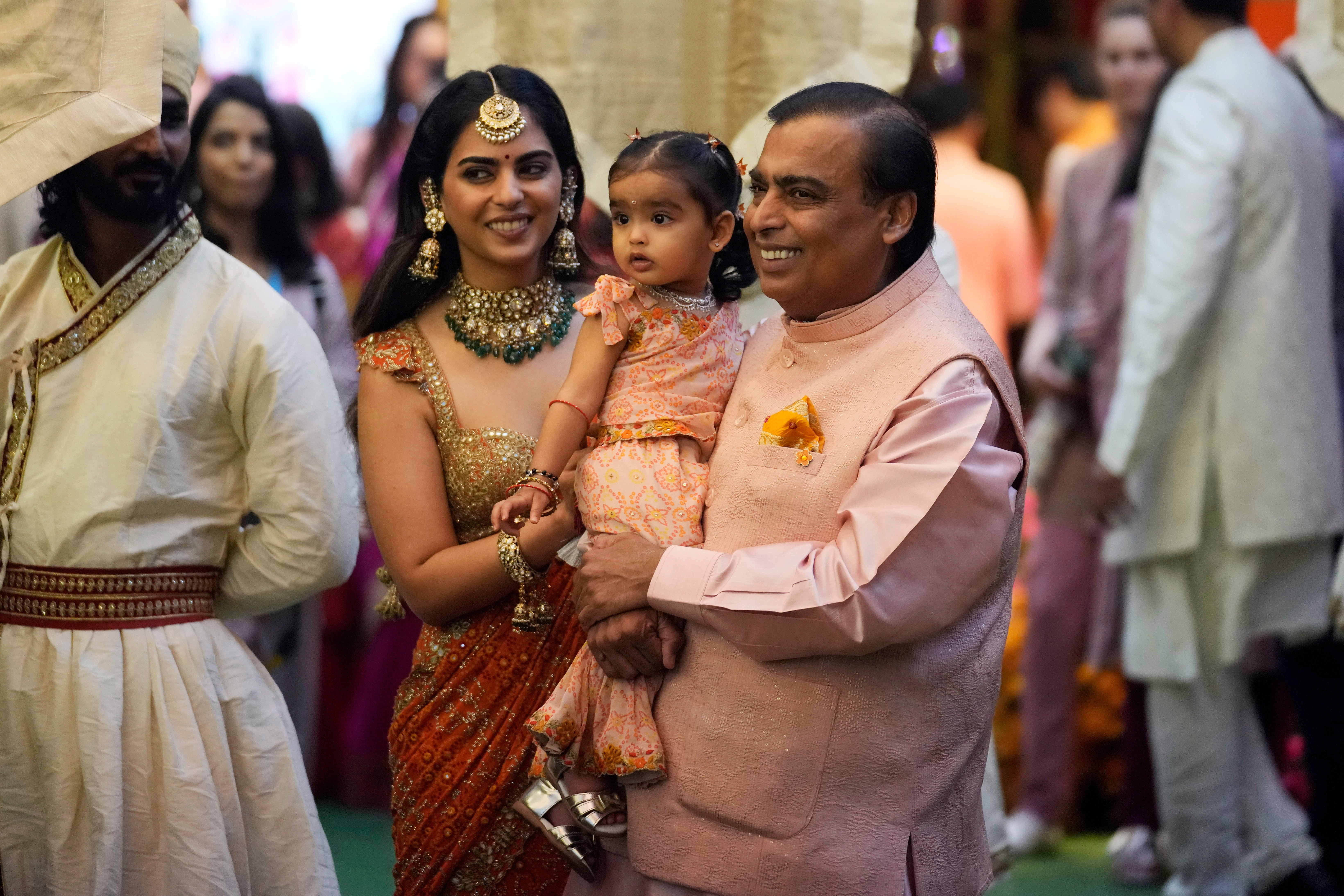 Mukesh, right, along with his daughter Isha and her daughter, greets guests during a pre-wedding ceremony