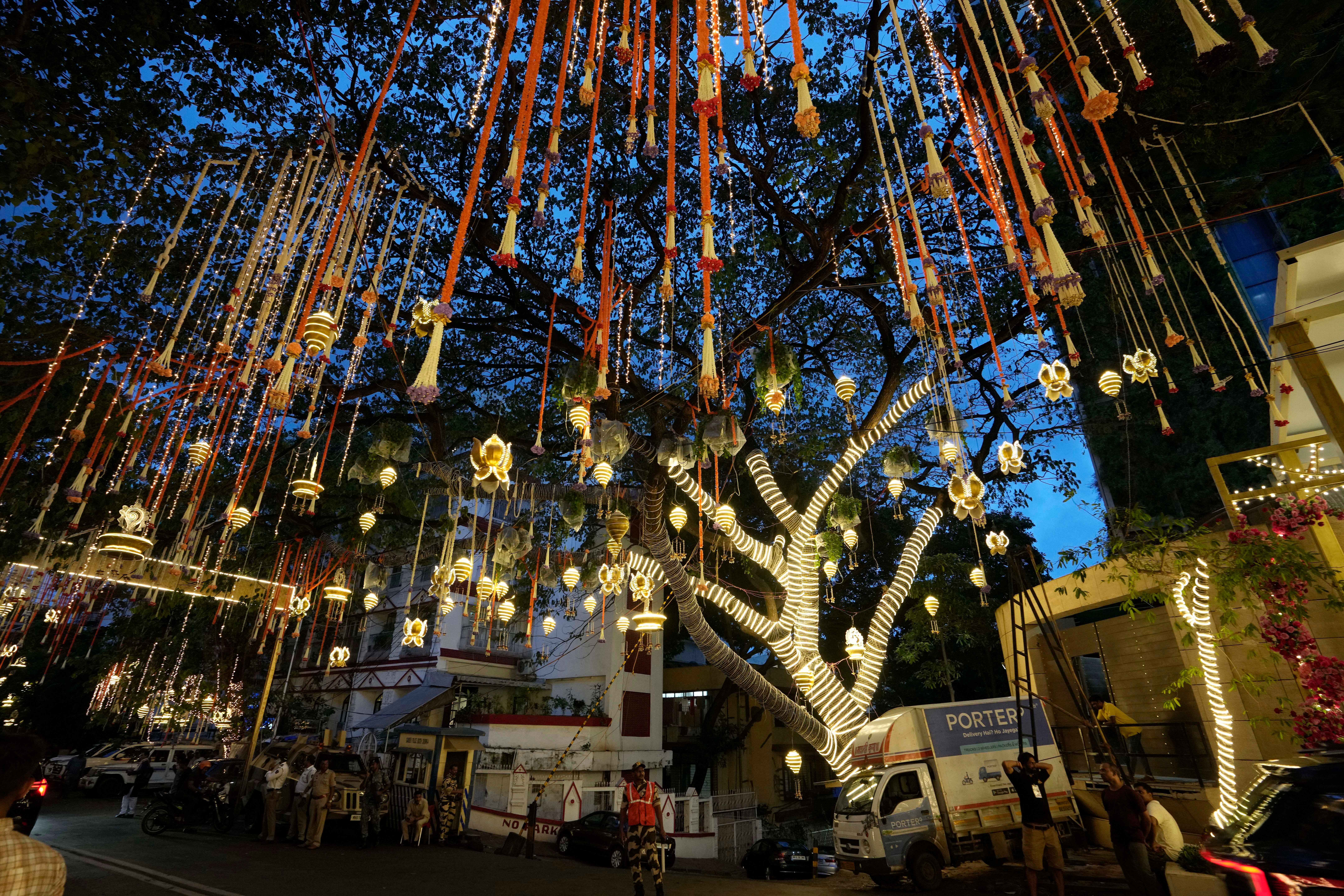 People walk past the Antilia mansion of Mukesh Ambani in Mumbai as it’s lit up ahead of his son Anant Ambani’s wedding