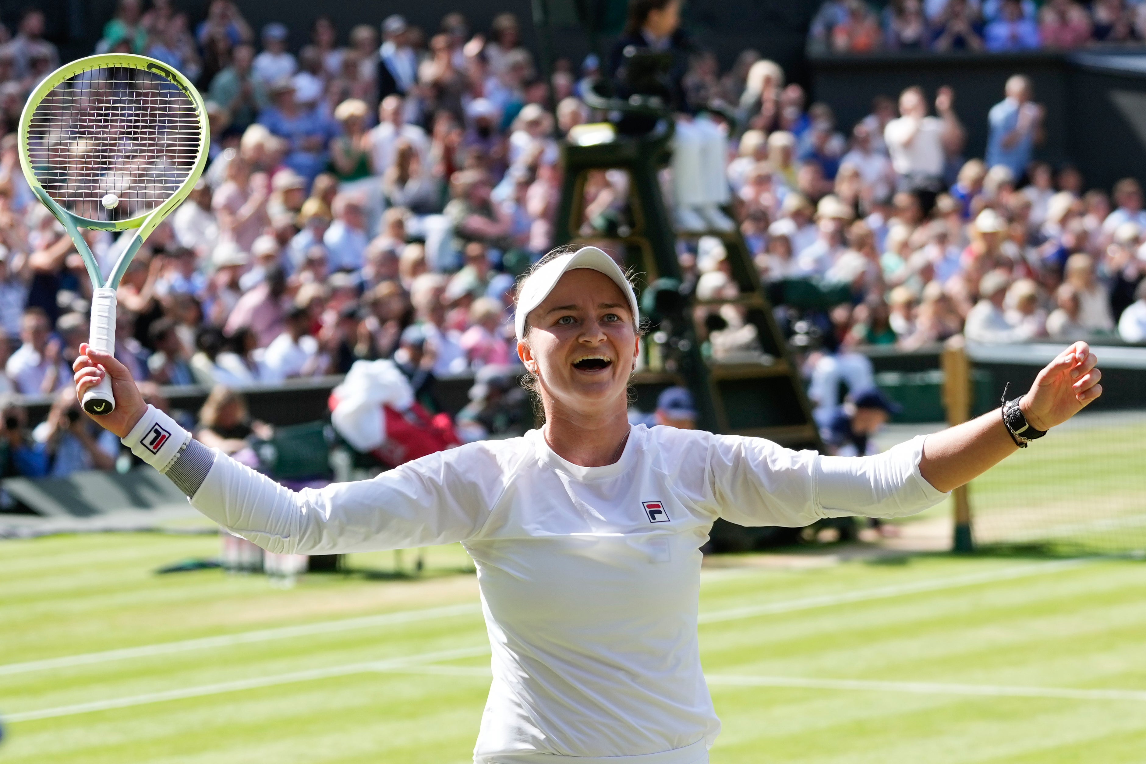 Krejcikova raises her arms aloft at the moment of triumph