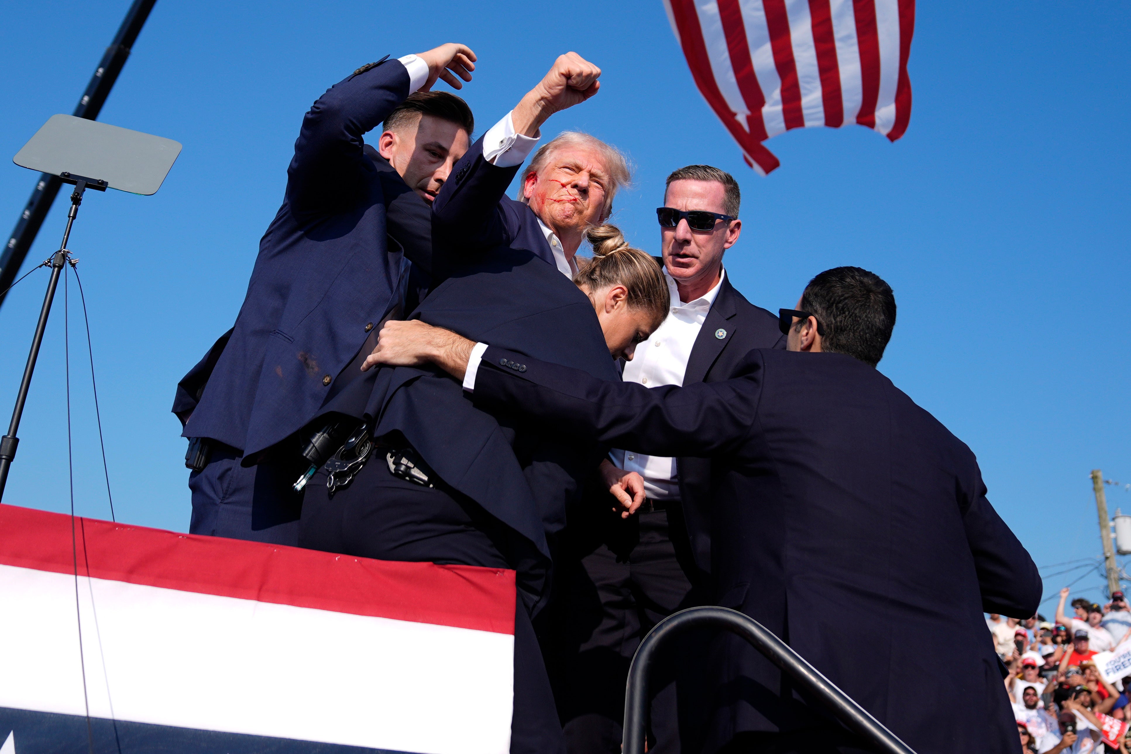 Secret Service agents lift Donald Trump and carry him away