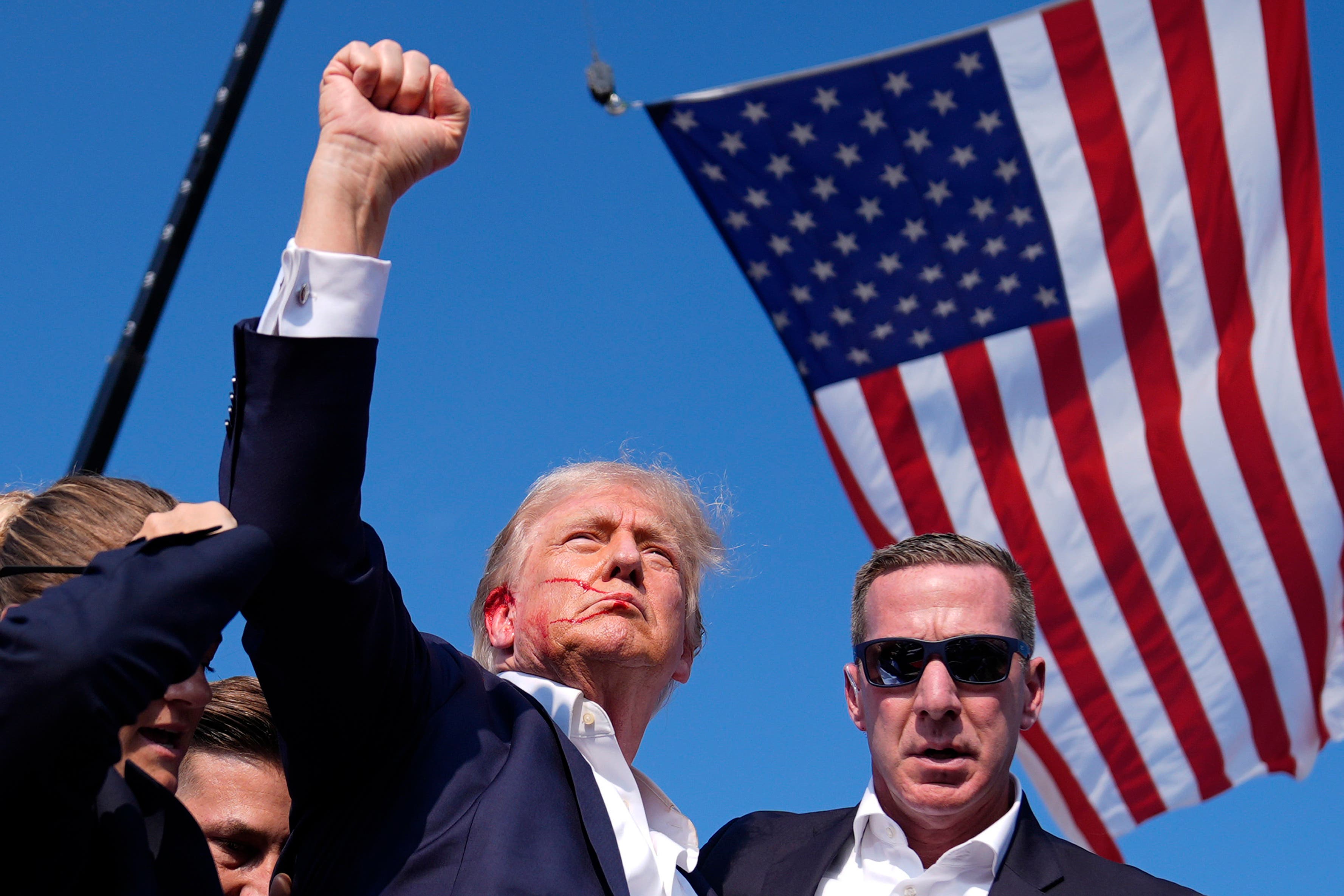 Republican presidential candidate former President Donald Trump reacts as he is surrounded by U.S. Secret Service agents a (AP Photo/Evan Vucci)