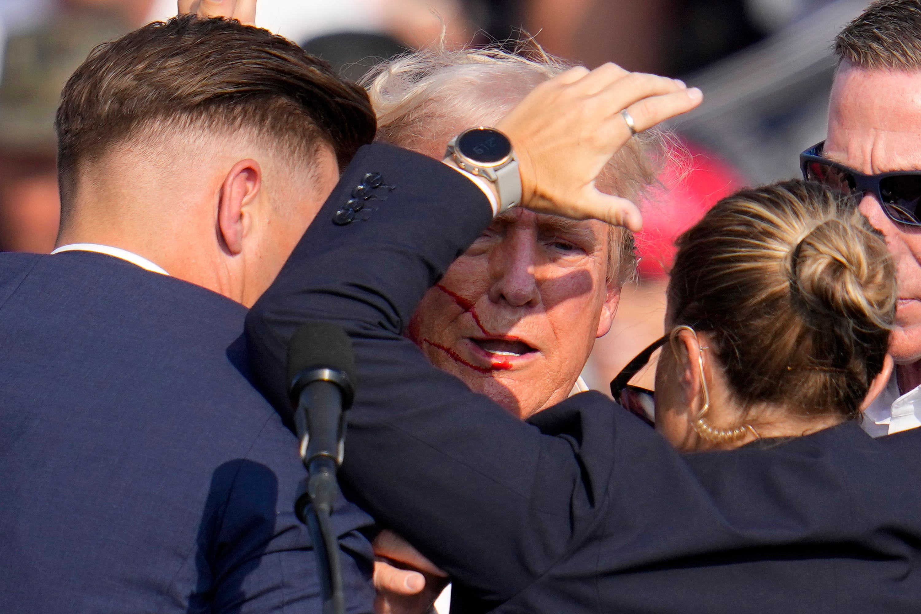 The former US president was helped off stage after he was targeted at a rally in Pennsylvania (Gene J Puskar/AP)