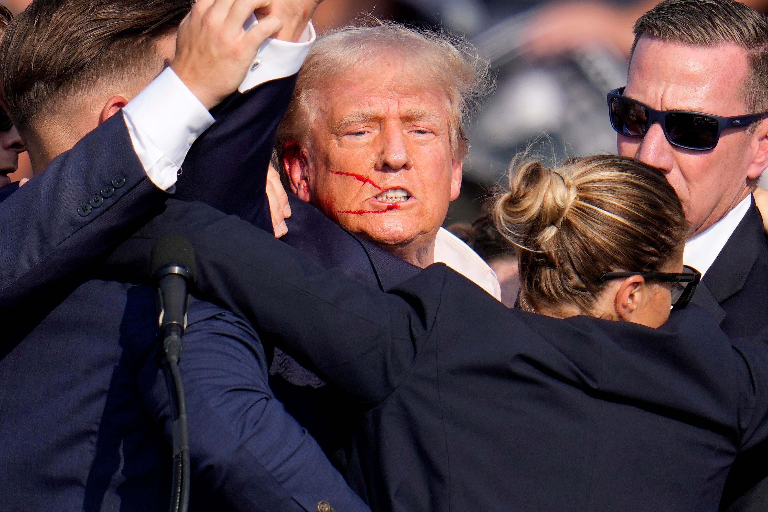 Republican presidential candidate former President Donald Trump is helped off the stage by U.S. Secret Service agents at a campaign event in Butler, Pa. (AP Photo/Gene J. Puskar)