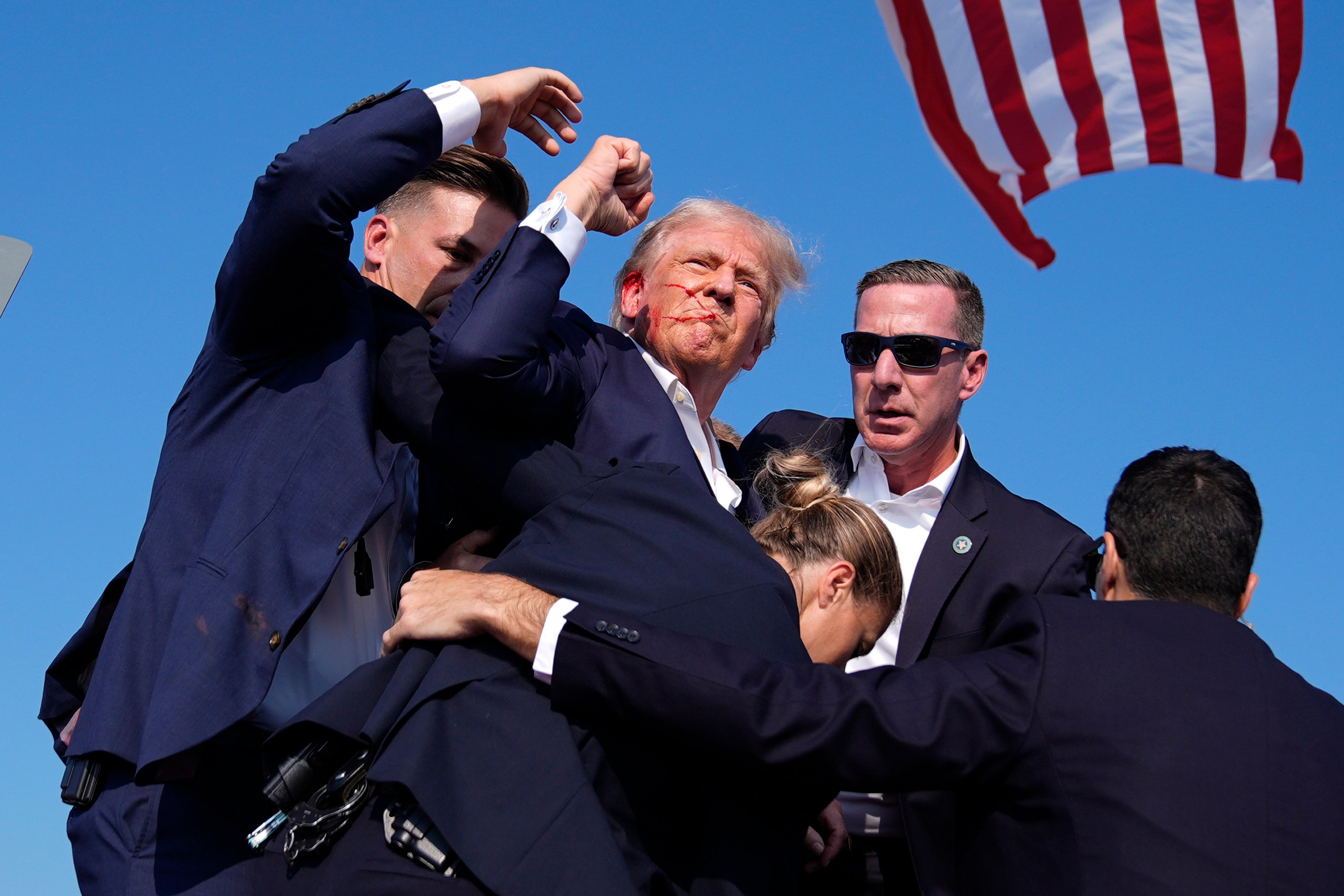 Trump raises fist in the air, showing he is okay, after an assassination attempt against him at his campaign rally in Butler, Pennsylvania. A GoFundMe he authorized has raised nearly $2 million for victims