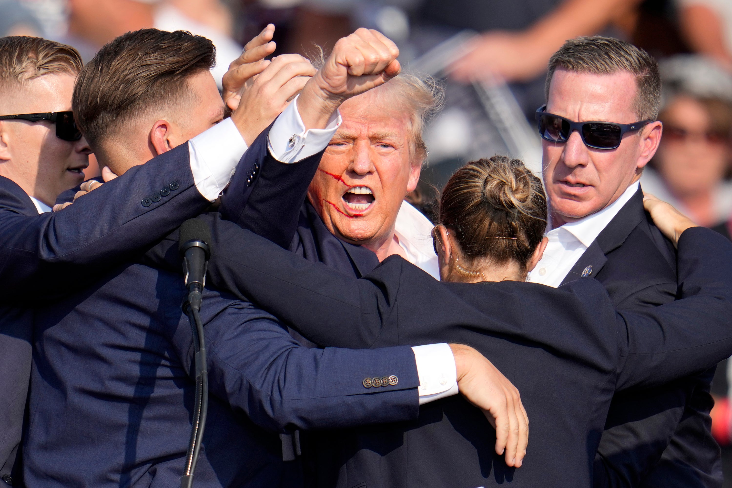 Republican presidential candidate Donald Trump is helped off the stage by Secret Service agents at a campaign event in Butler, Pennsylvania on July 13, 2024