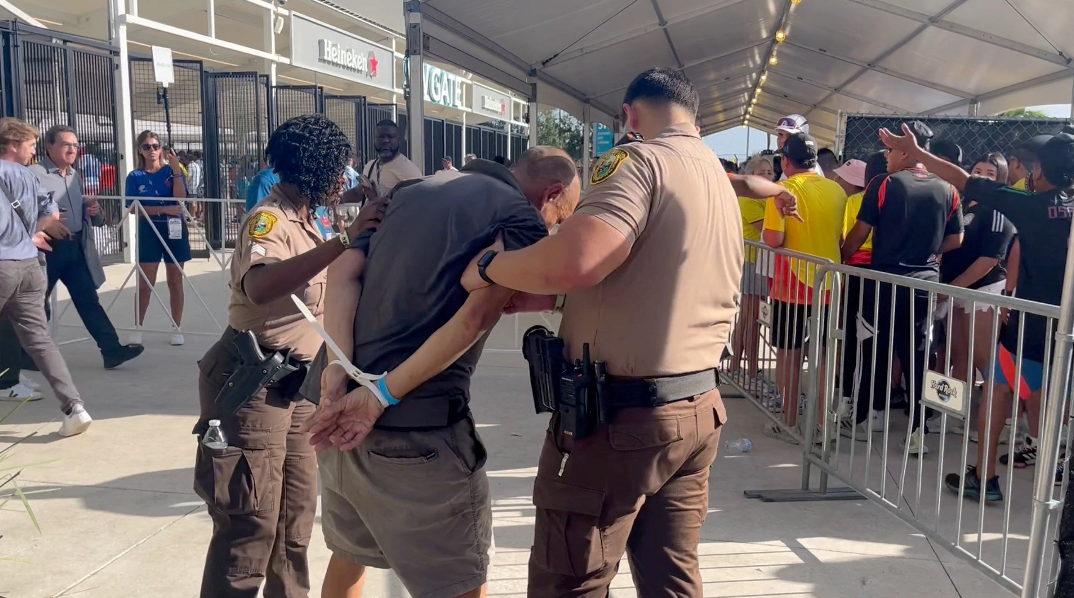 A man is detained by the police at Hard Rock Stadium in Miami