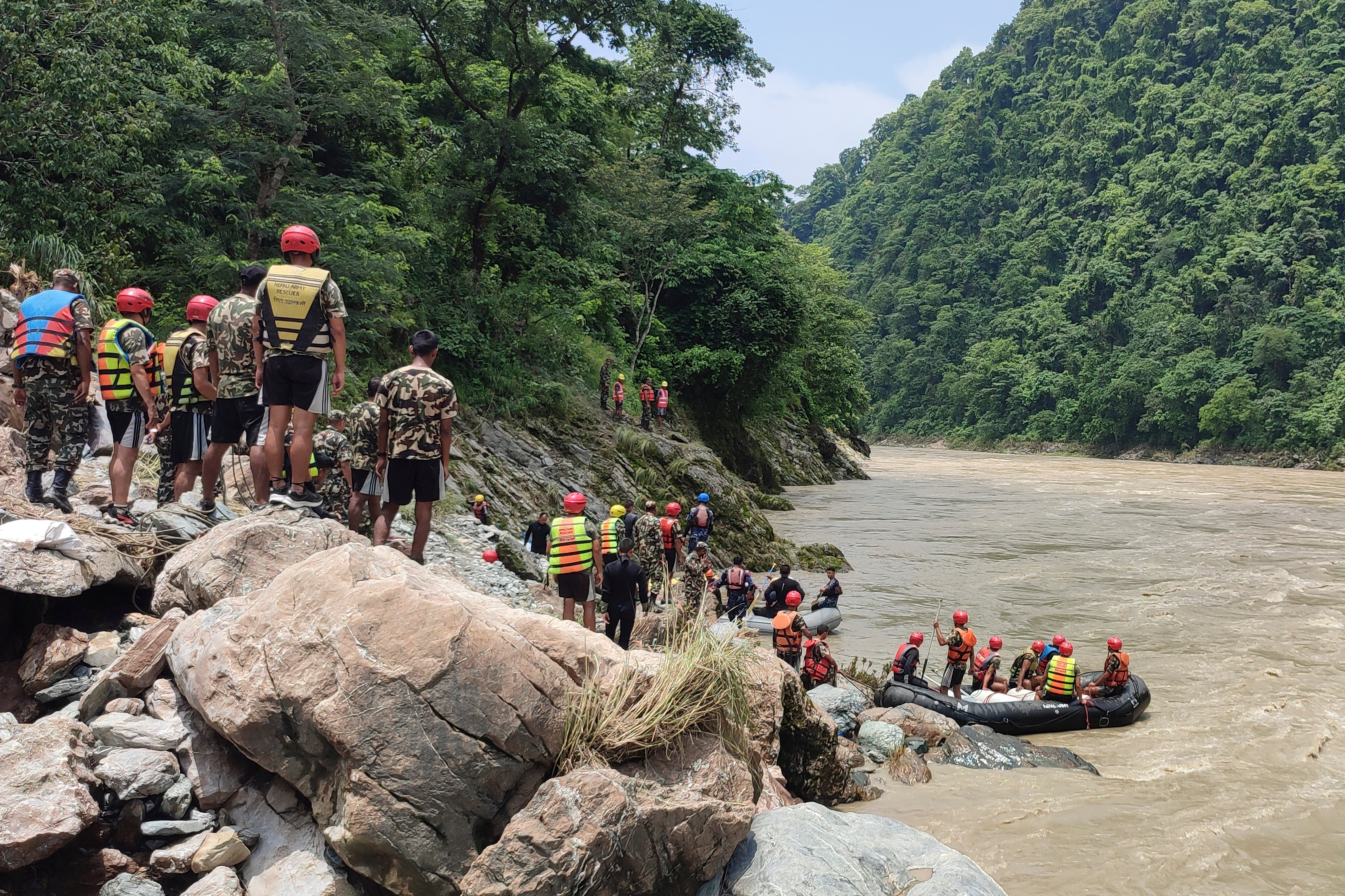 Nepalese army personnel carry out a search operation after a landslide swept away two buses into a swollen river near Simaltal