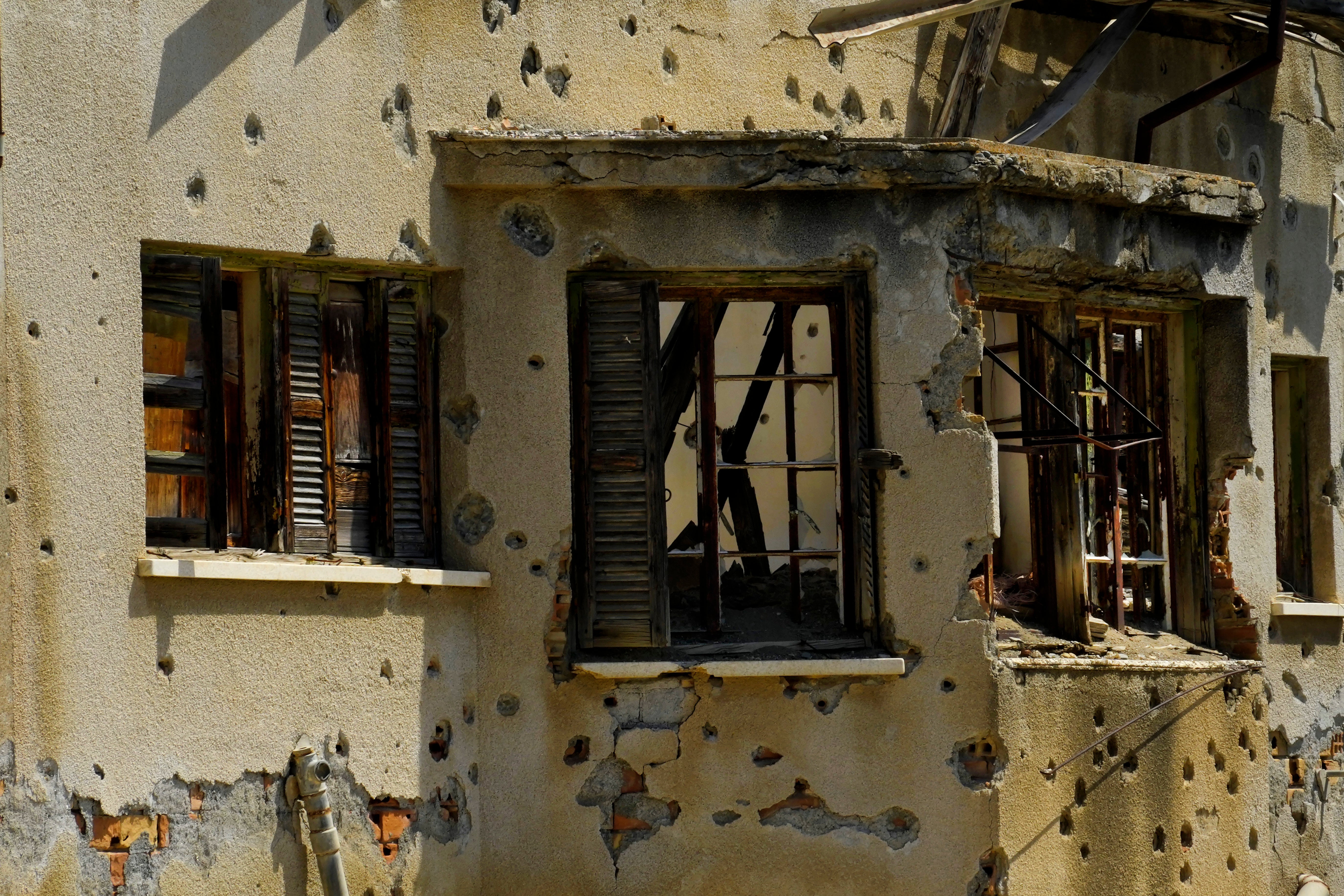 The holes from bullets are seen on an abandoned building inside the war-torn U.N. buffer zone