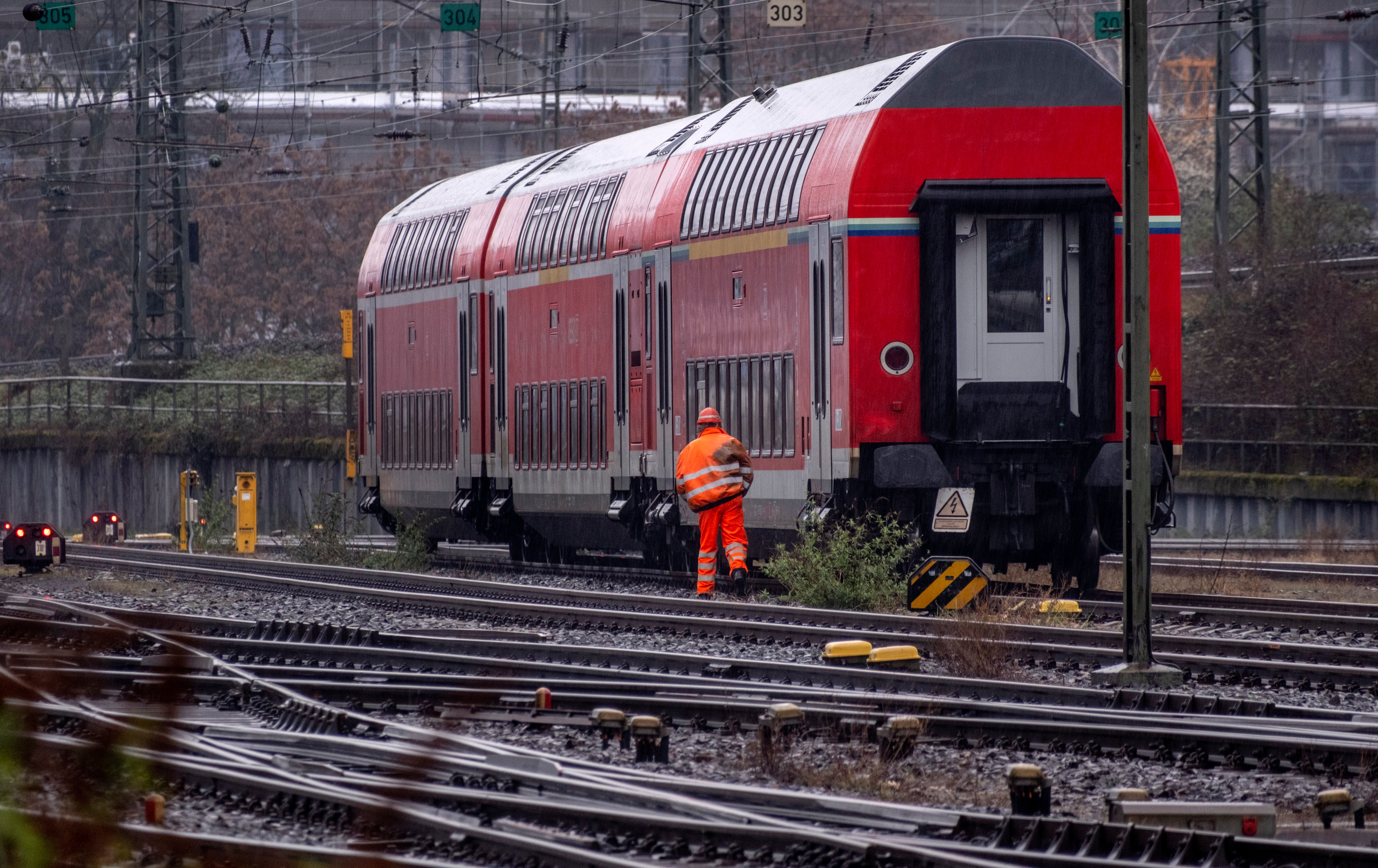 A railway worker walks along a parked train outside the central train station in Frankfurt, Germany