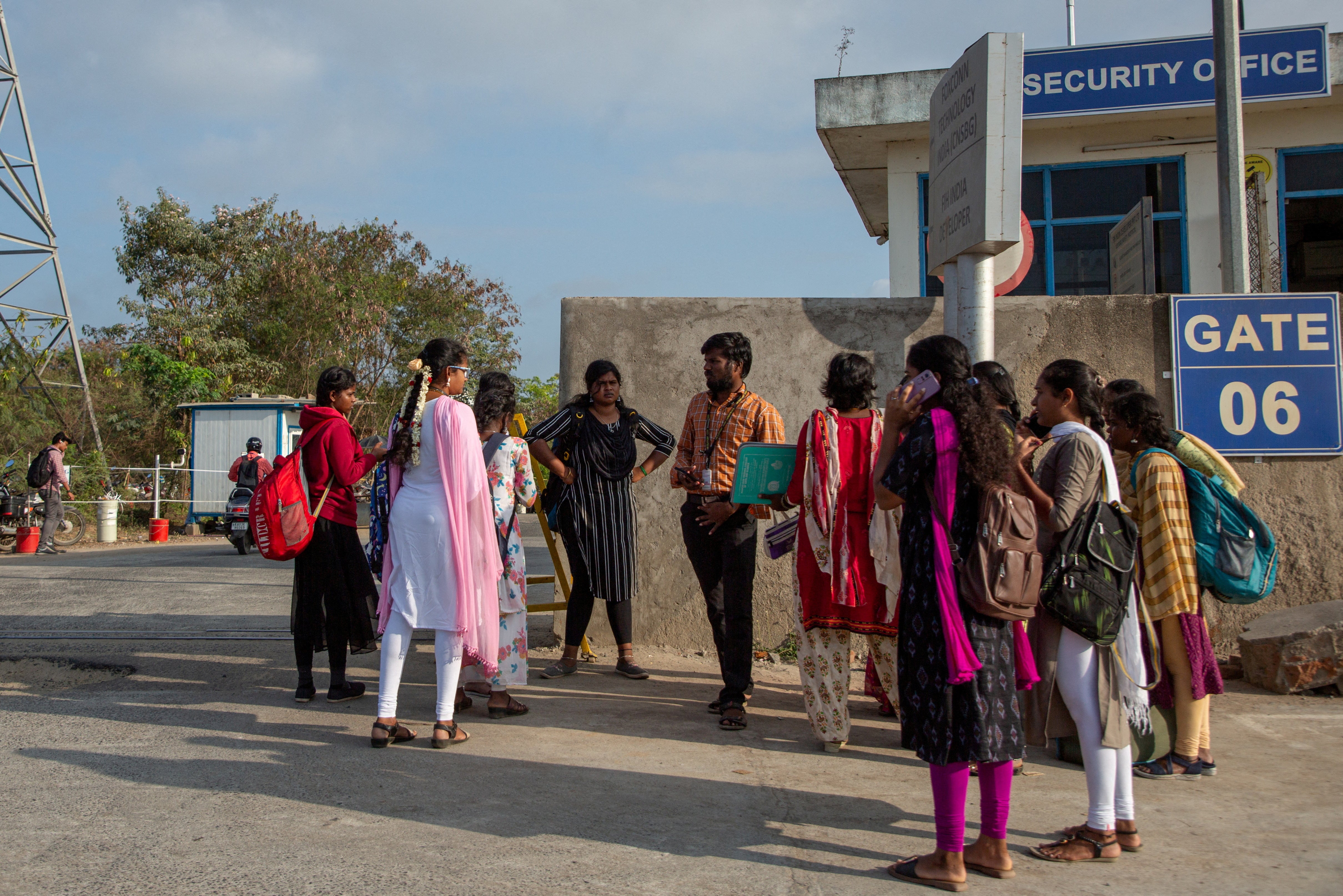 Job aspirants talk with a hiring agent outside the Foxconn factory, where workers assemble iPhones for Apple, in Sriperumbudur, near Chennai, India, 1 April 2024