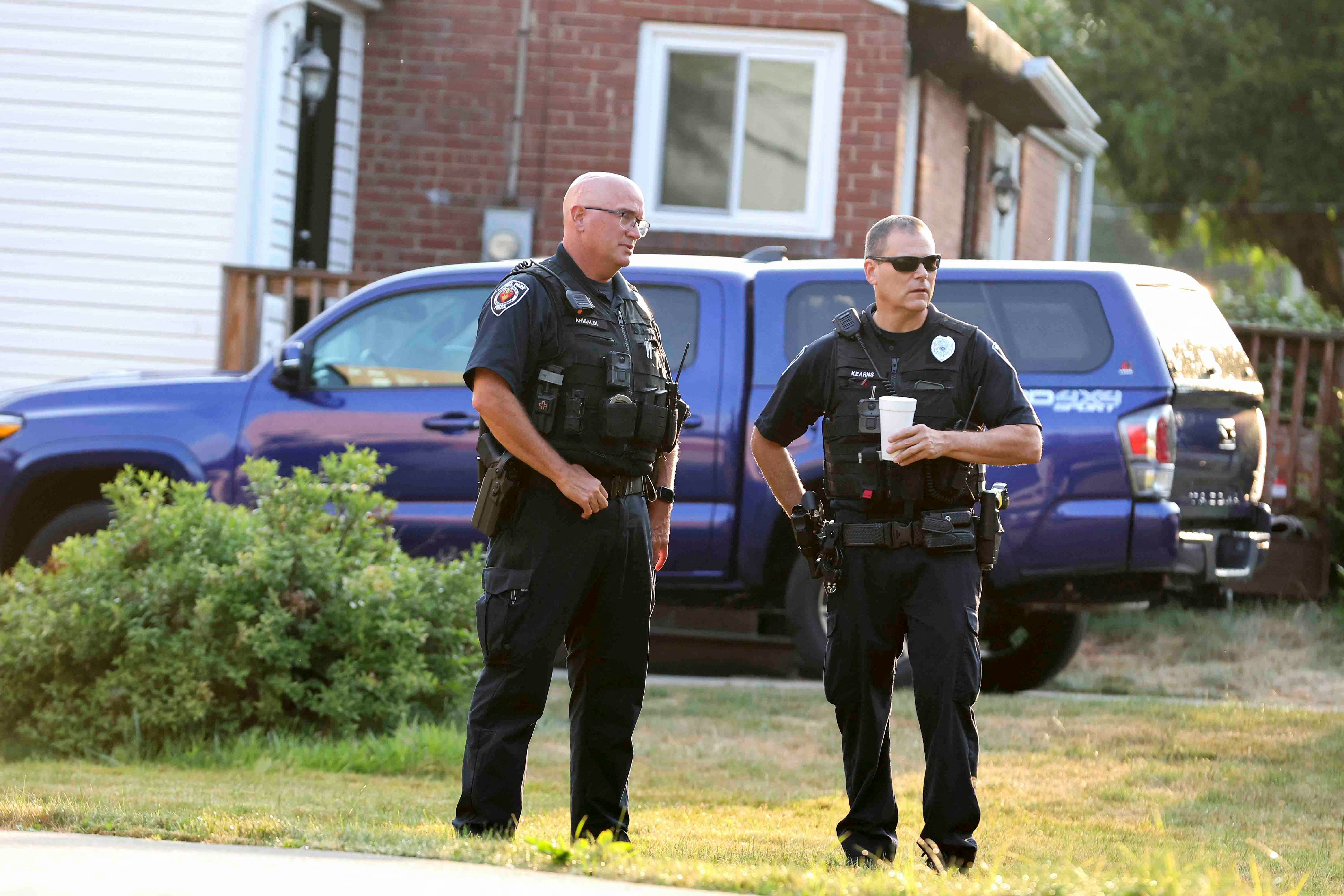 Police officers talk near the home of Trump shooting suspect Thomas Crooks