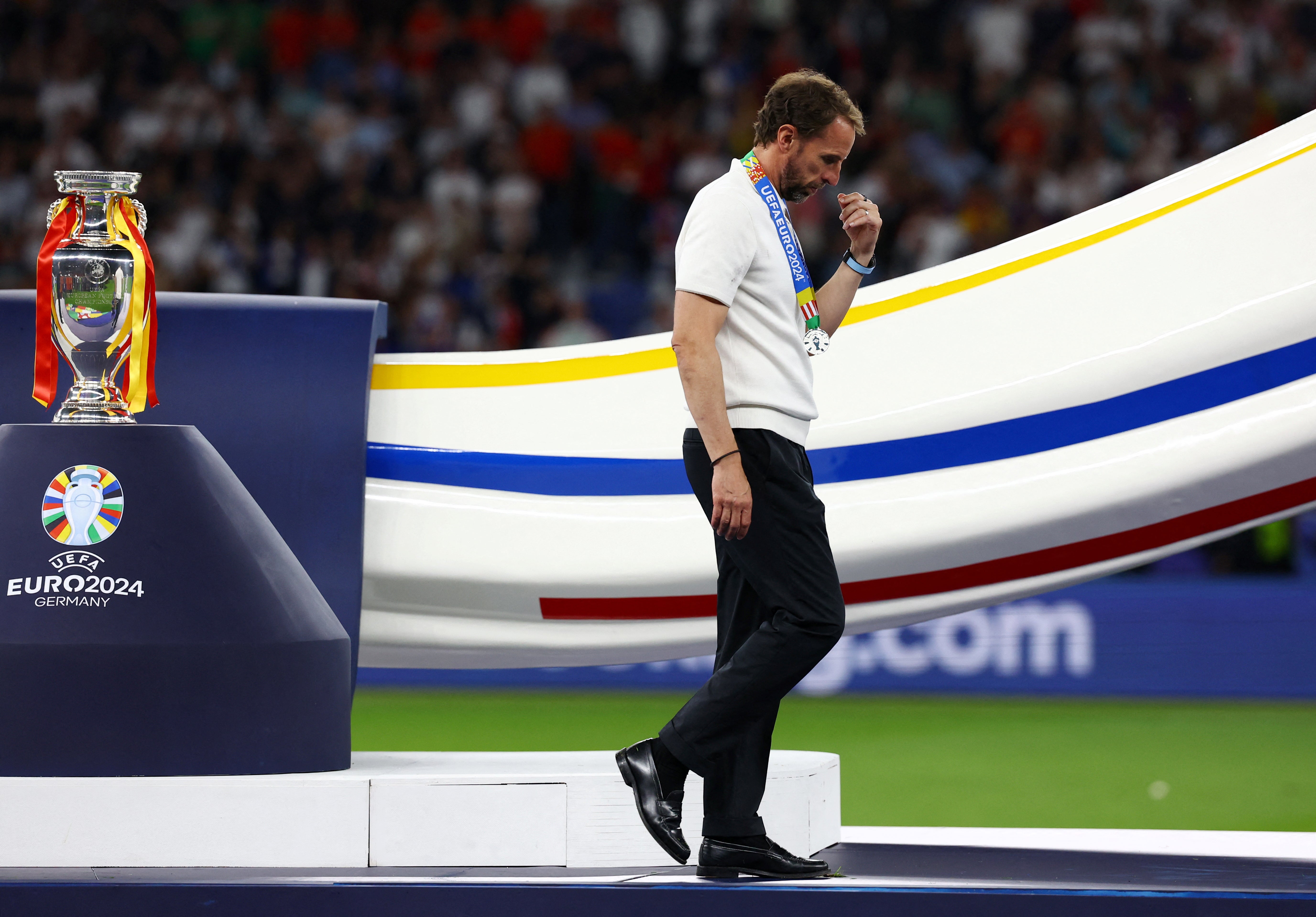 A dejected Gareth Southgate walks past the trophy