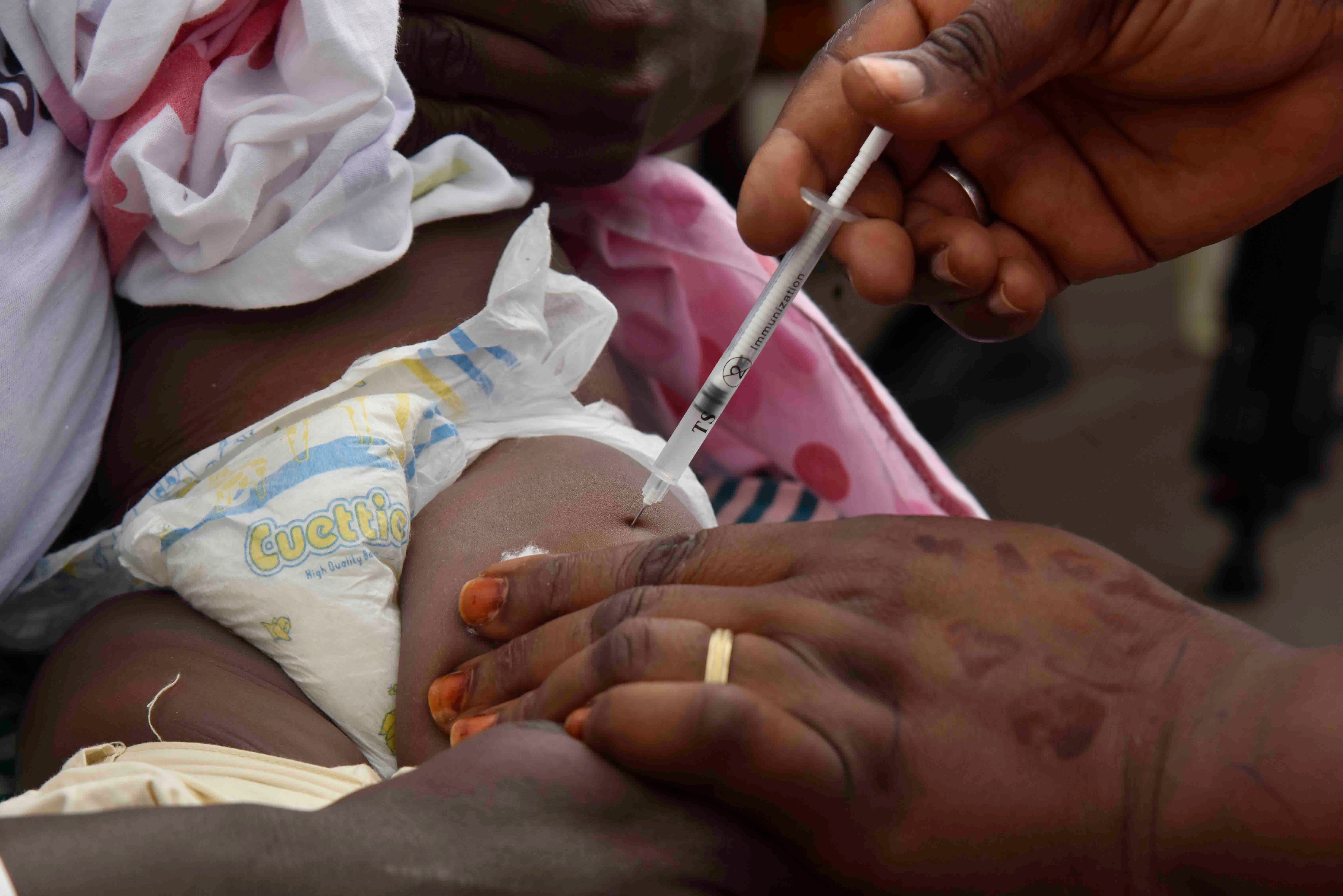 A health worker administers the malaria vaccine Oxford-Serum R21 to a child in Abidjan, Ivory Coast