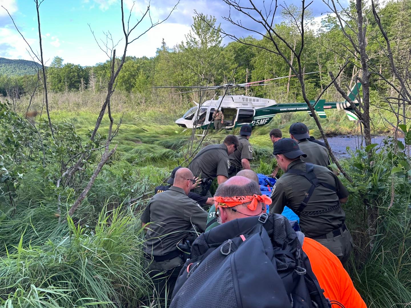 Maine search and rescue personnel escort Michael Altmaier, a man who went missing and was later found in a bog near Mount Blue State Park Scenic Overlook, to a waiting helicopter on July 12, 2024