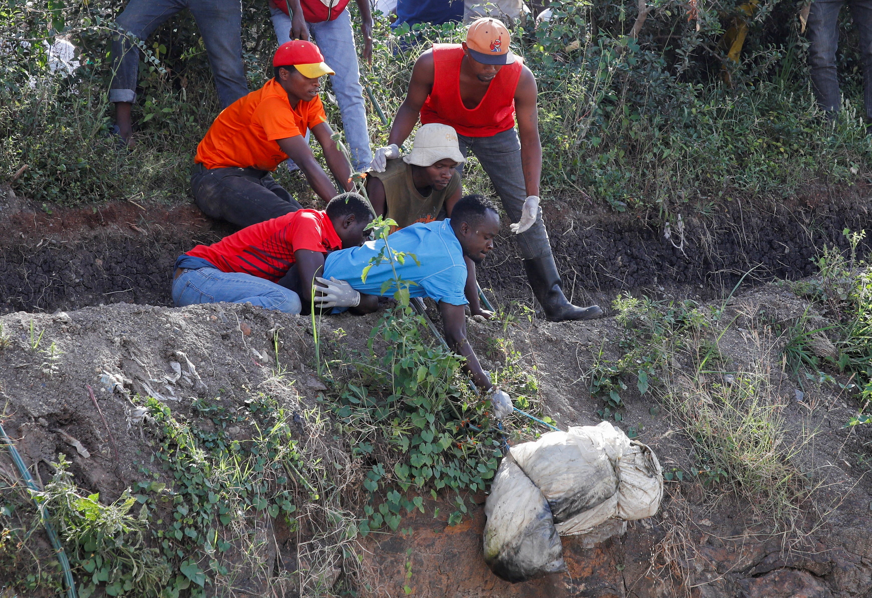 Volunteers carry a body of an unknown person retrieved from a dumpsite at Mukuru in Nairobi, Kenya, on 12 July 2024