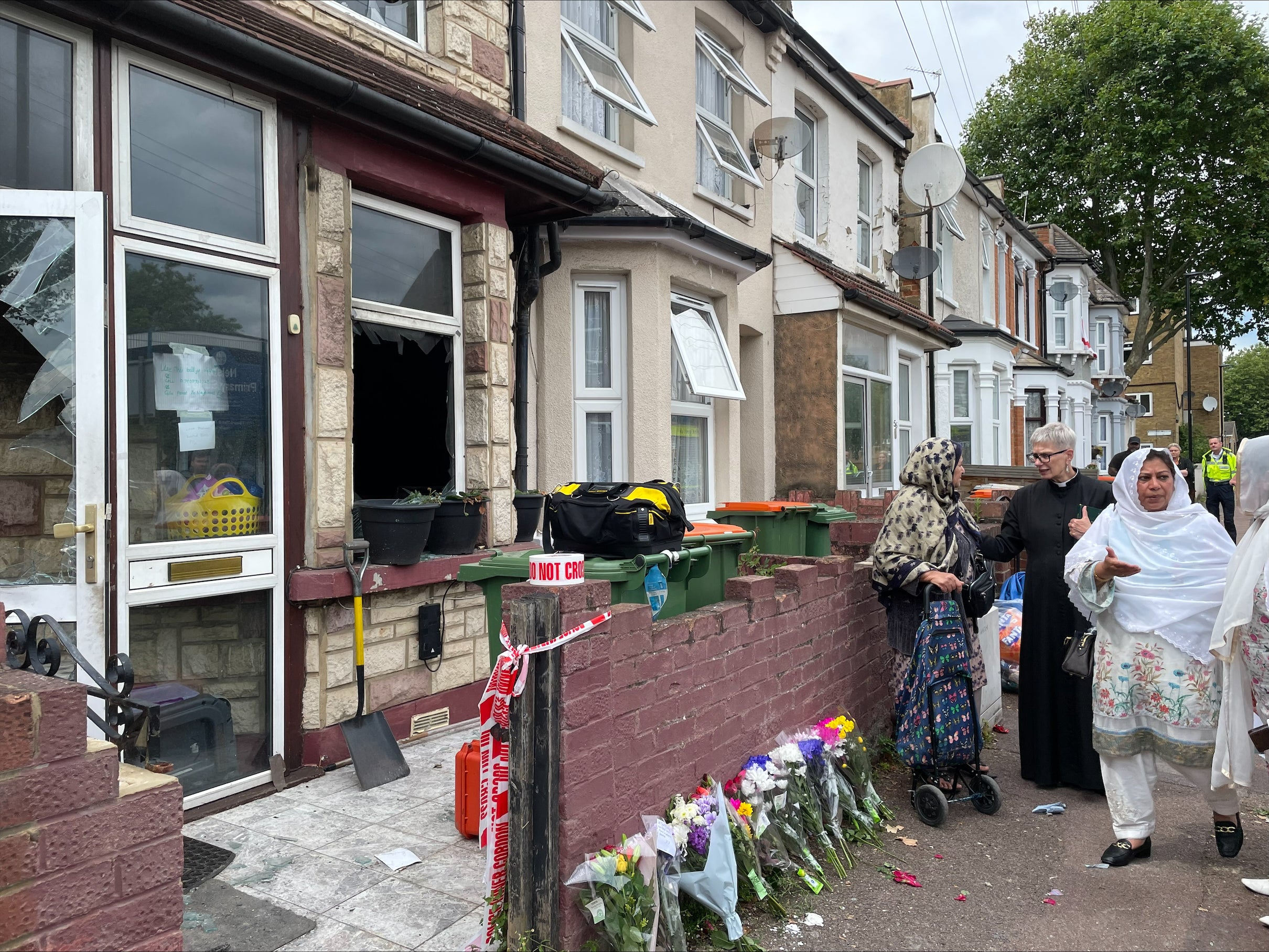 Flowers are left at the scene in Napier Road, East Ham, London