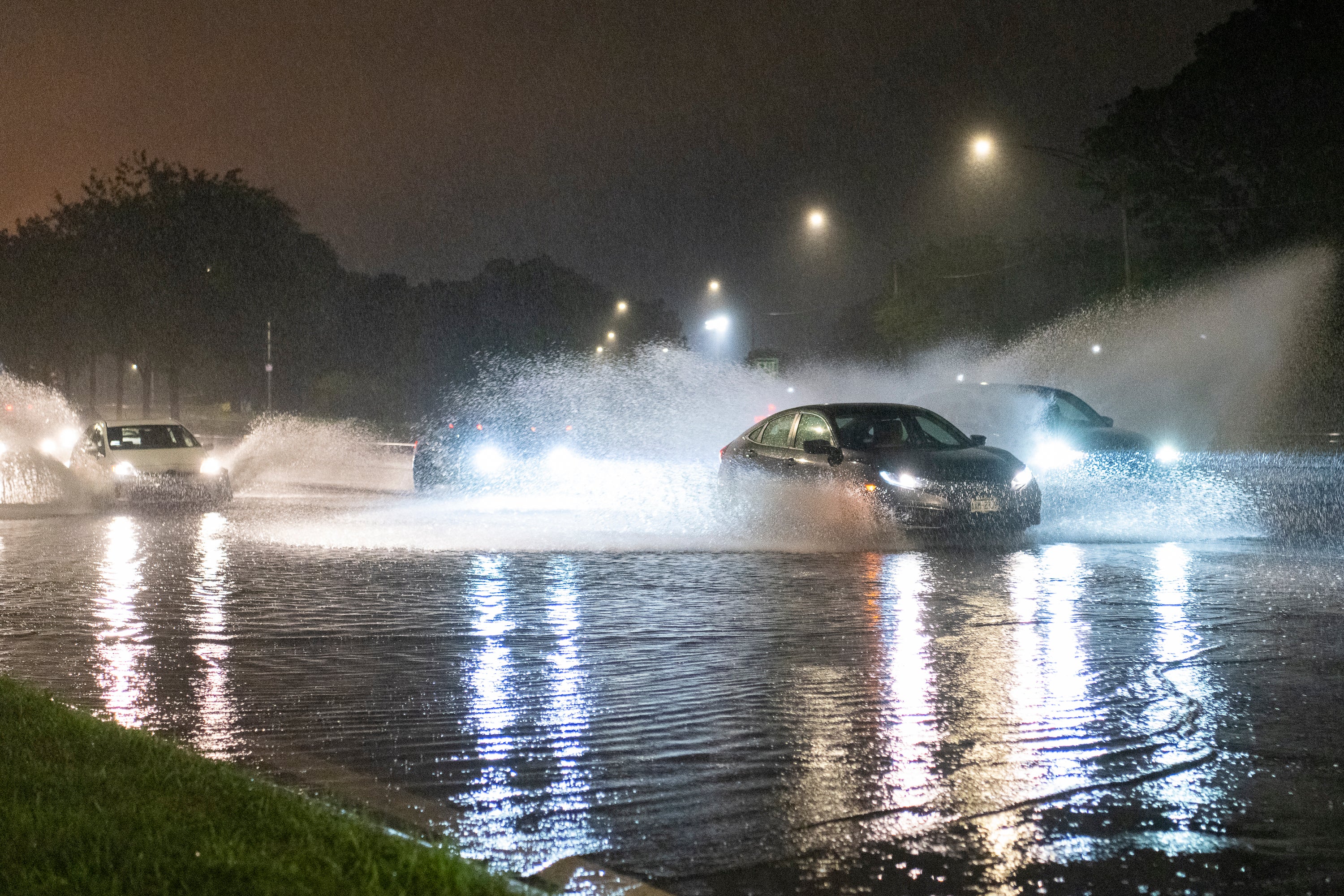 Cars drive through a flooded section of DuSable Lake Shore Drive as severe storms lash Illinois this week