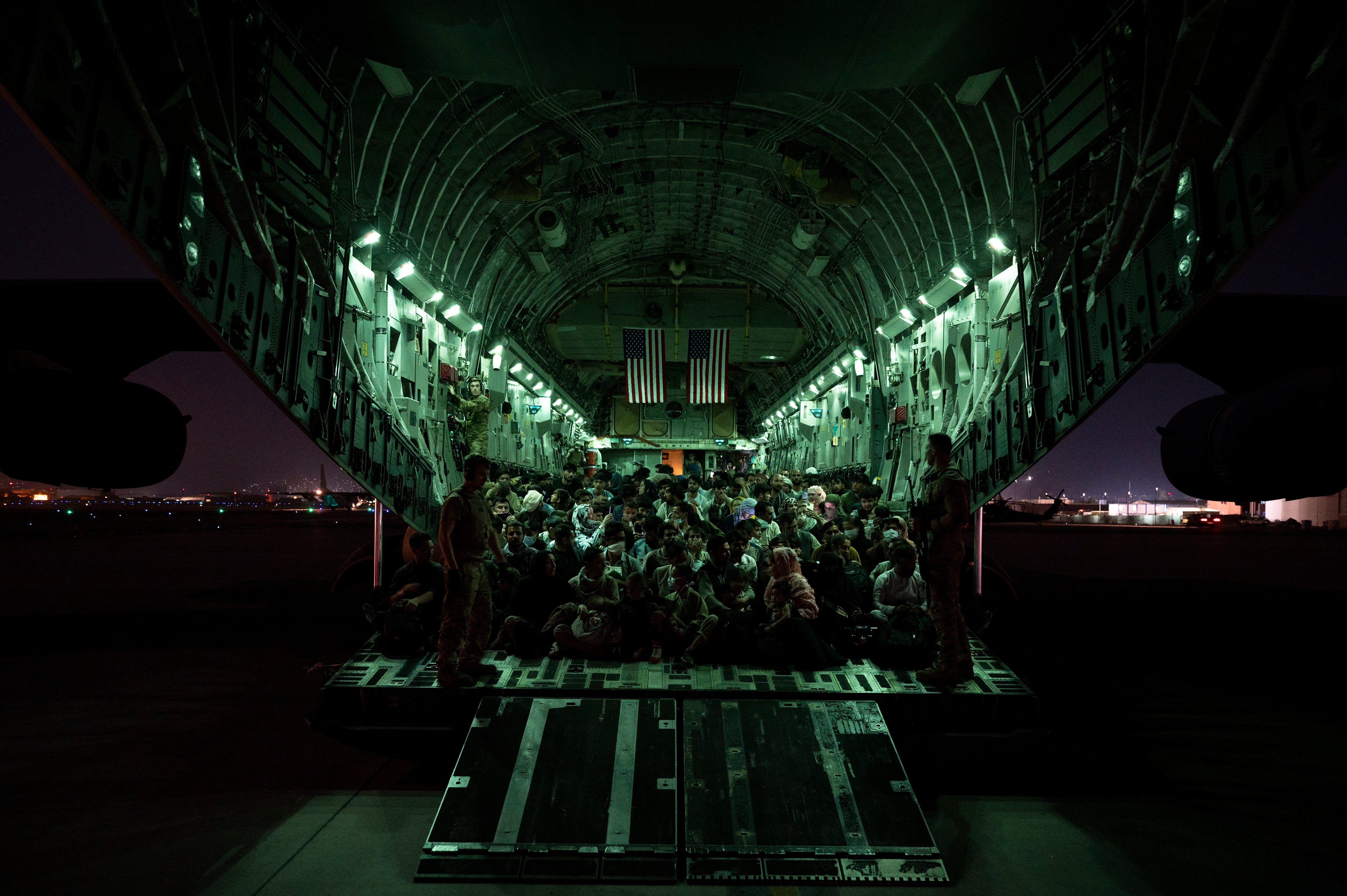 A US Air Force crew assists evacuees aboard an aircraft after the Taliban took Kabul in 2021