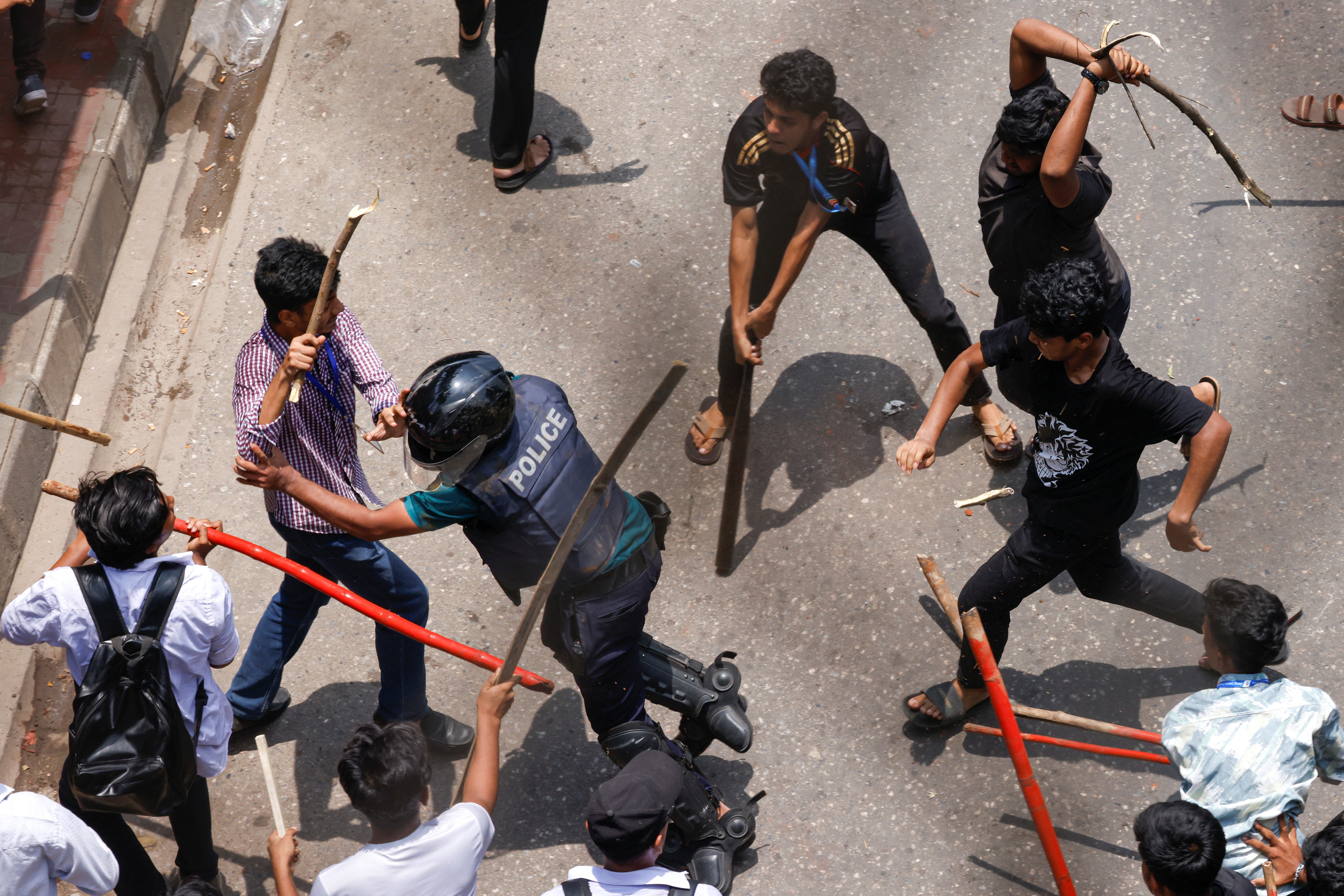 A police officer is beaten by mob during a clash between anti-quota supporters, police and Awami League supporters at the Rampura area in Dhaka