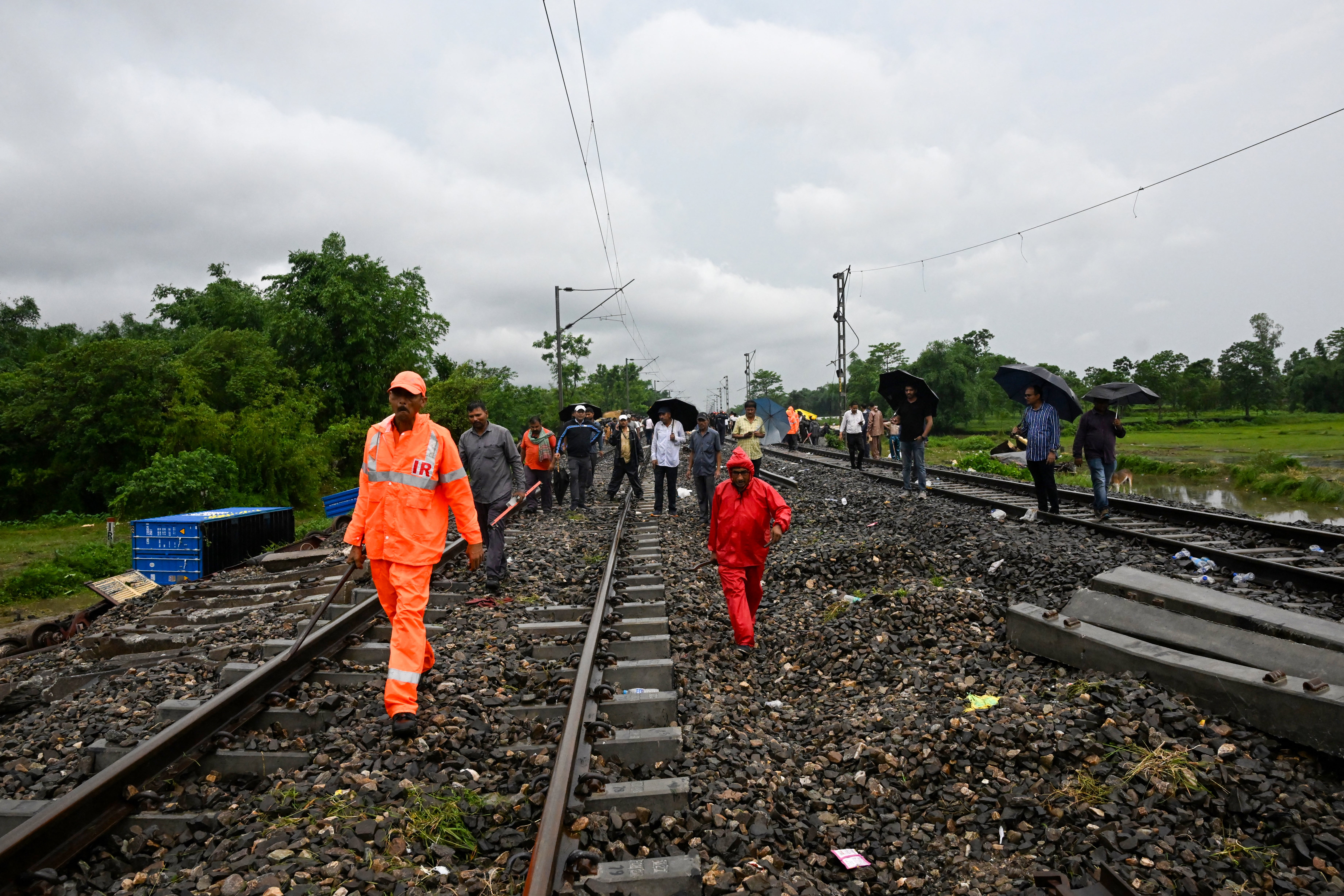 Railway workers and National Disaster Response Force (NDRF) personnel inspect the accident site of passenger train in India