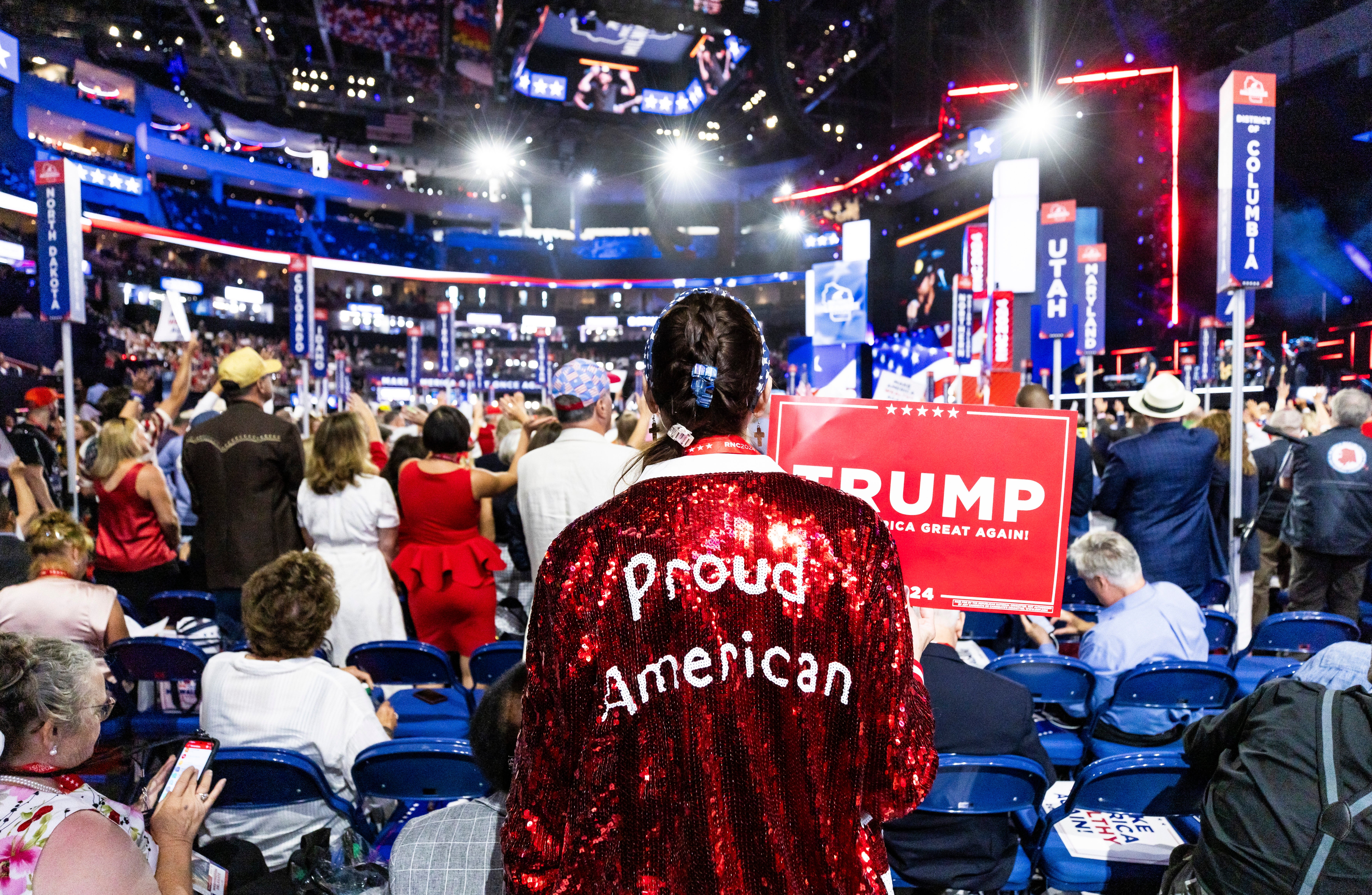 A delegate wearing a sequined boxer-style robe reading ‘Proud American’ in white letters