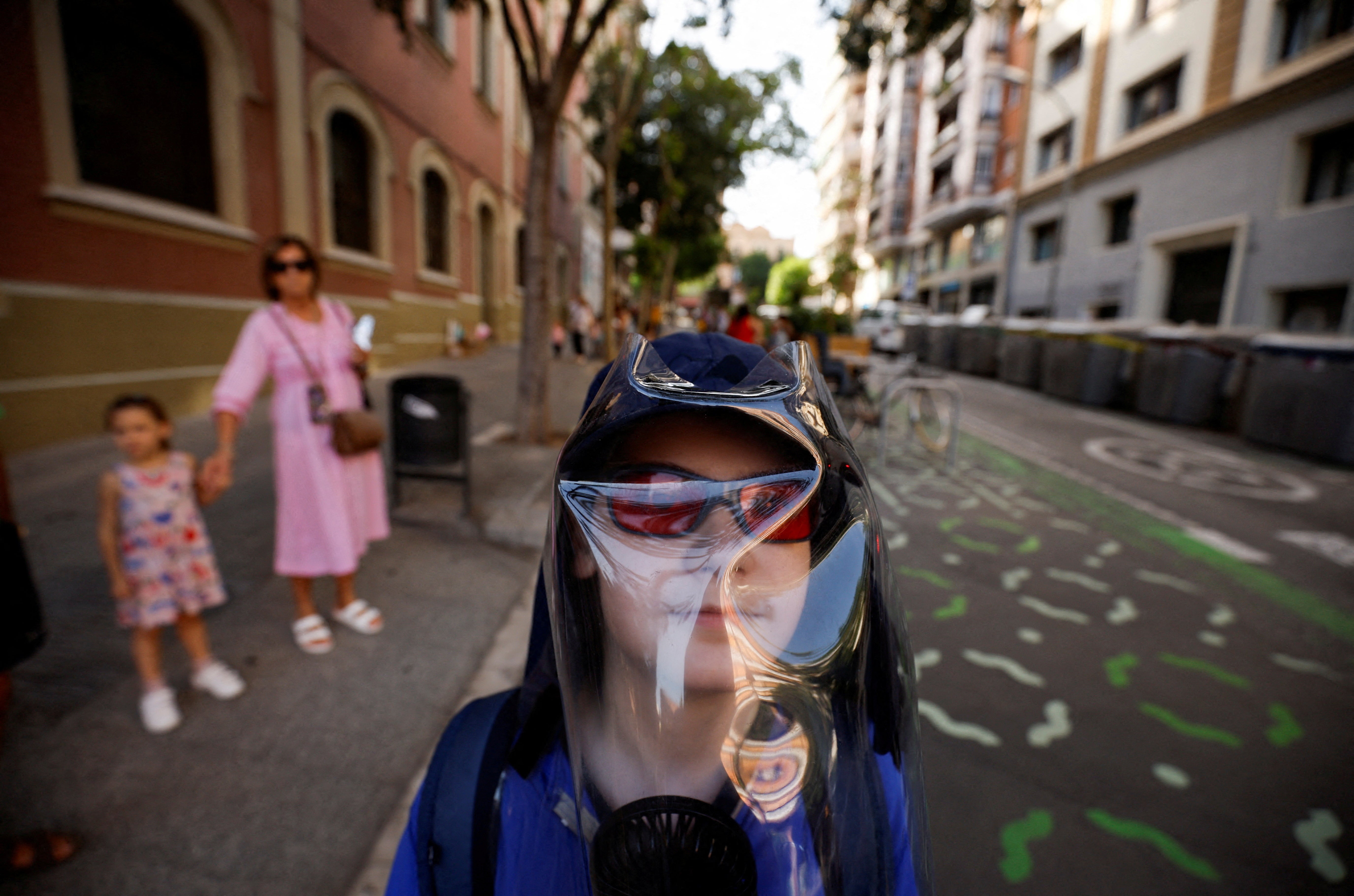 Pol Dominguez Aranda, 11, who is diagnosed with Xeroderma pigmentosum - extreme sensitivity to ultraviolet rays - walks the street in shadowed areas wearing UV protection gear