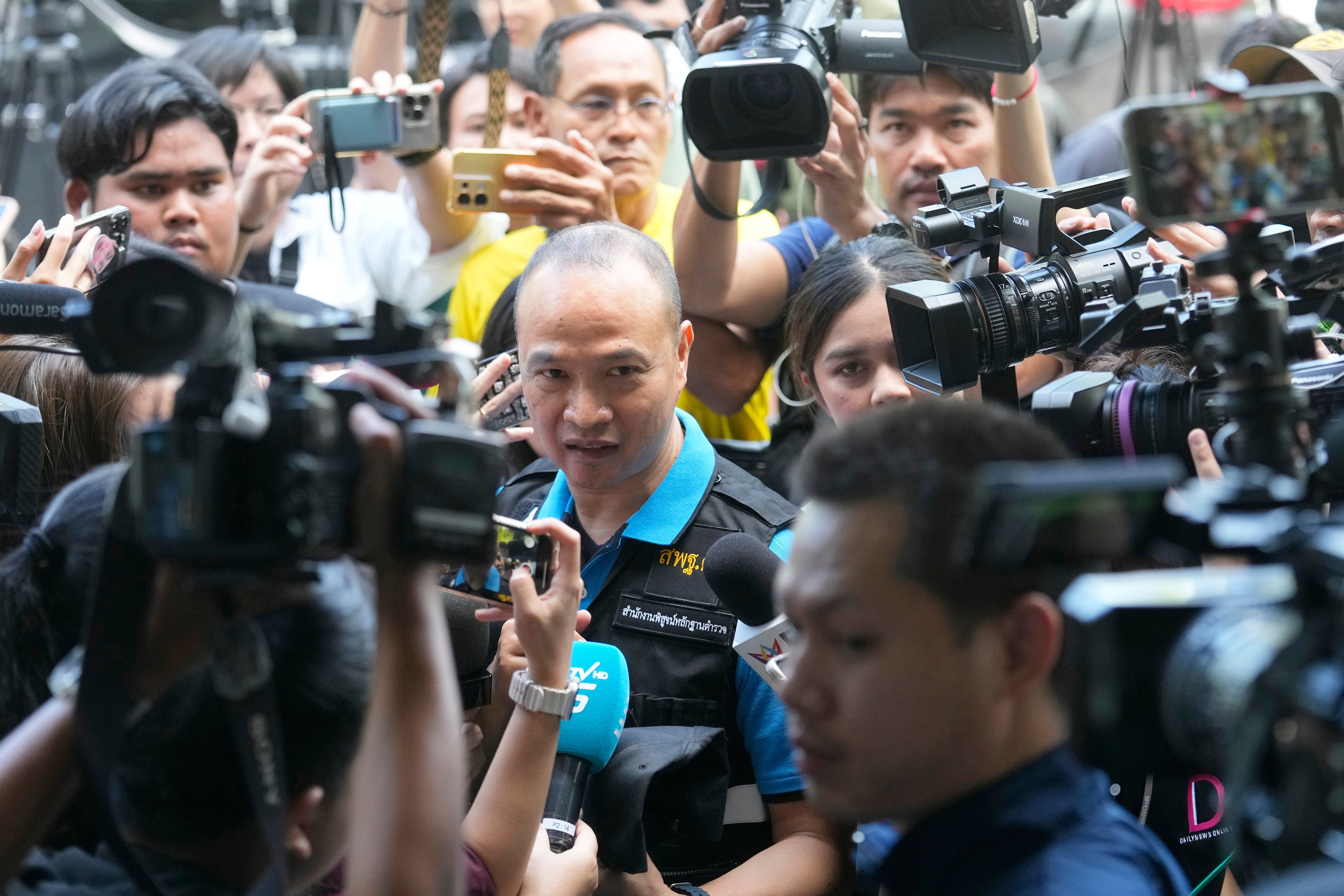 Lt. Gen. Trairong Piwpan, center, chief of the Thai police force’s forensic division, talks to reporters during a press conference