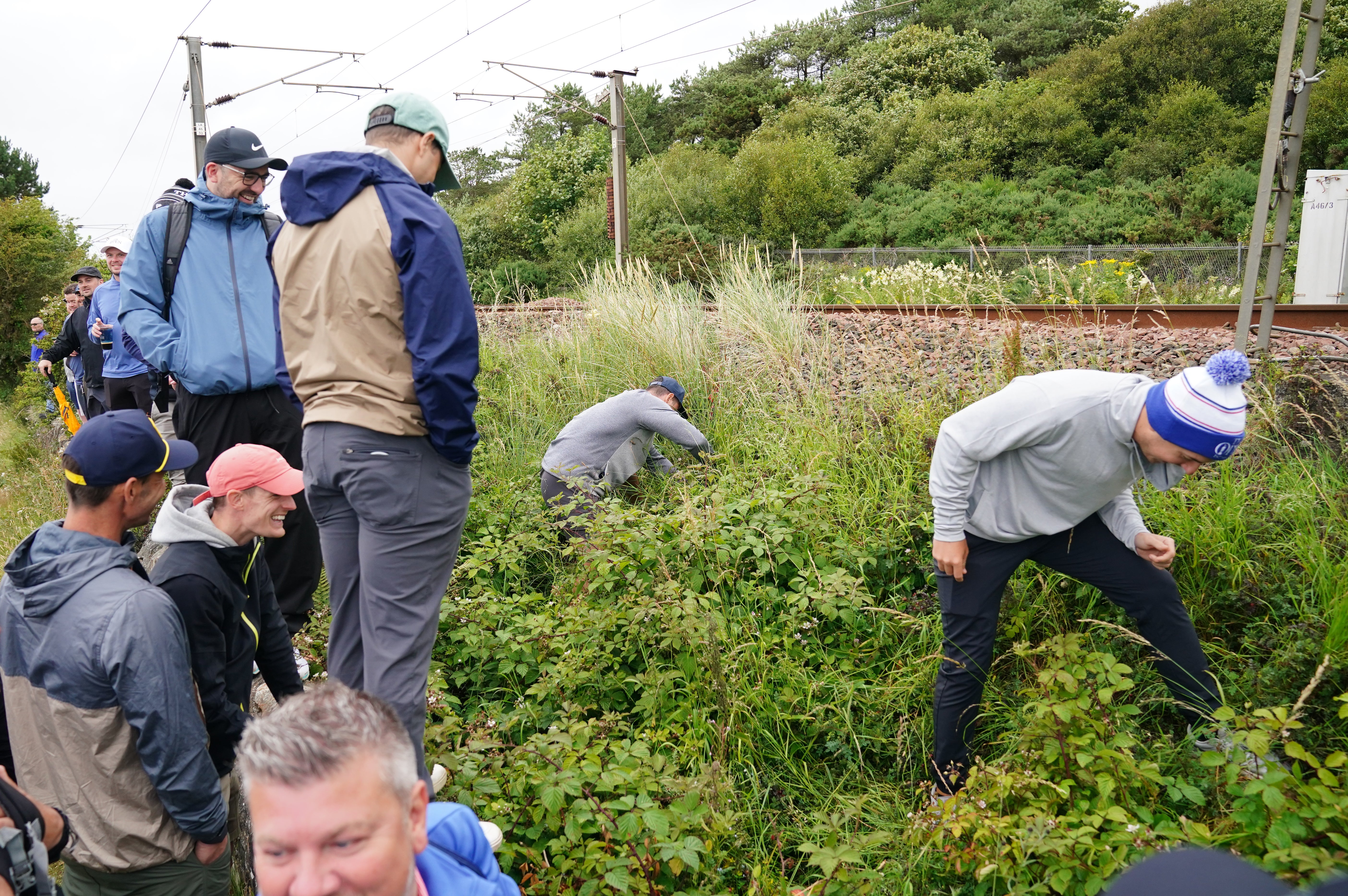 Spectators search for Rory McIlroy’s ball after he drove out of bounds on the 11th (Jane Barlow/PA)