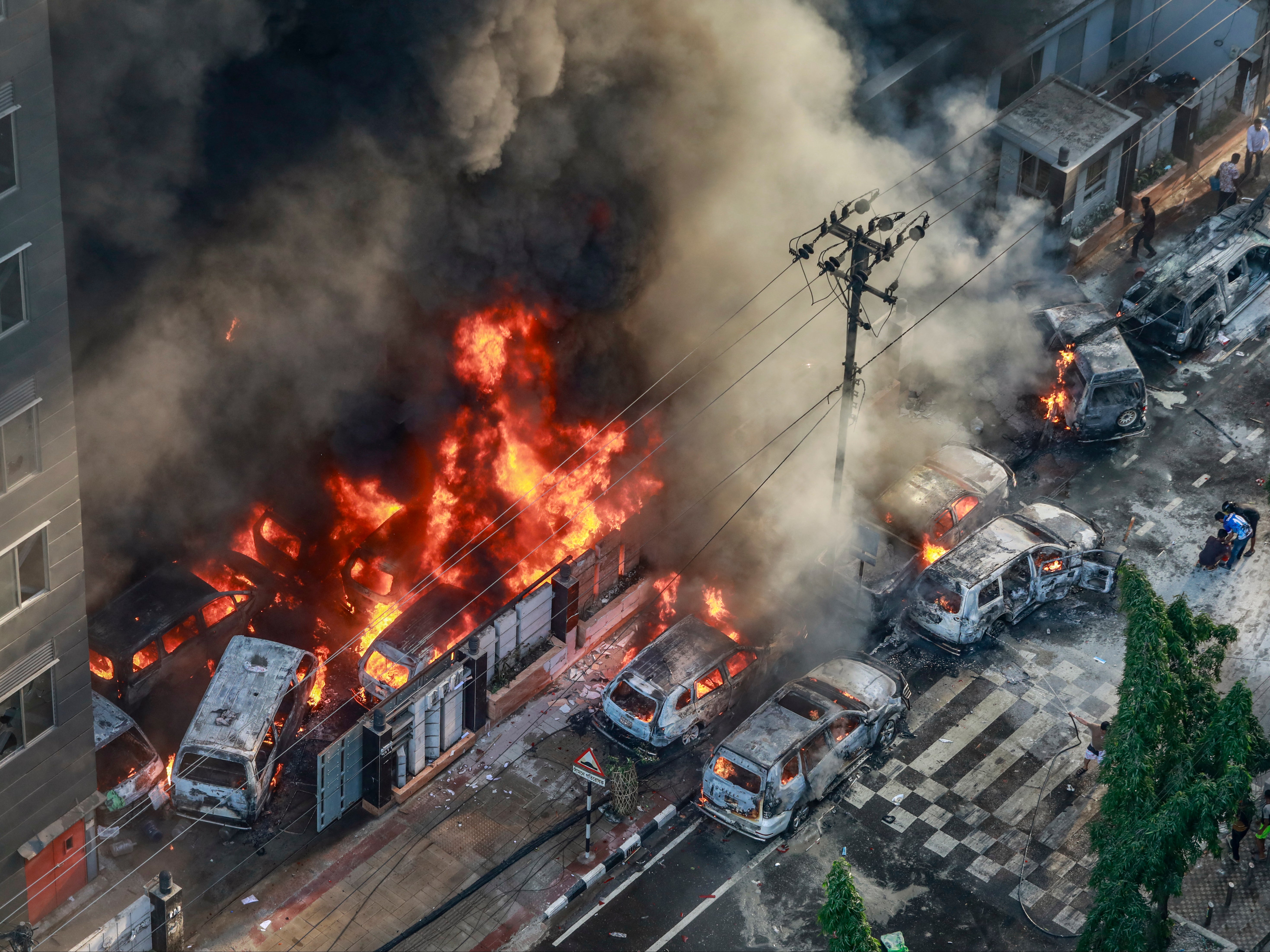 Smoke rises from vehicles set on fire by protesters in Dhaka on 18 July 2024