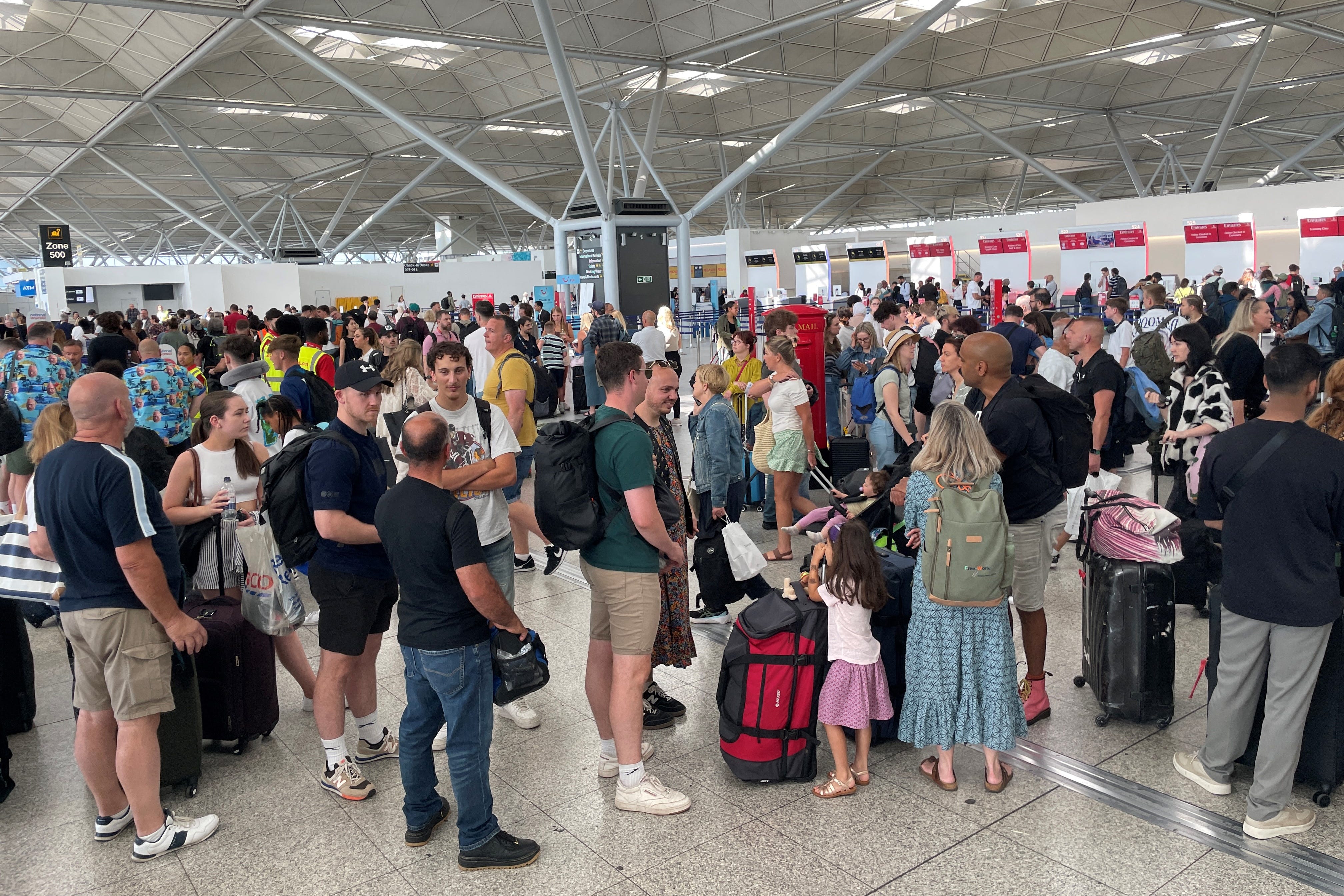 Passengers queueing at London Stansted Airport (Joe Giddens/PA)