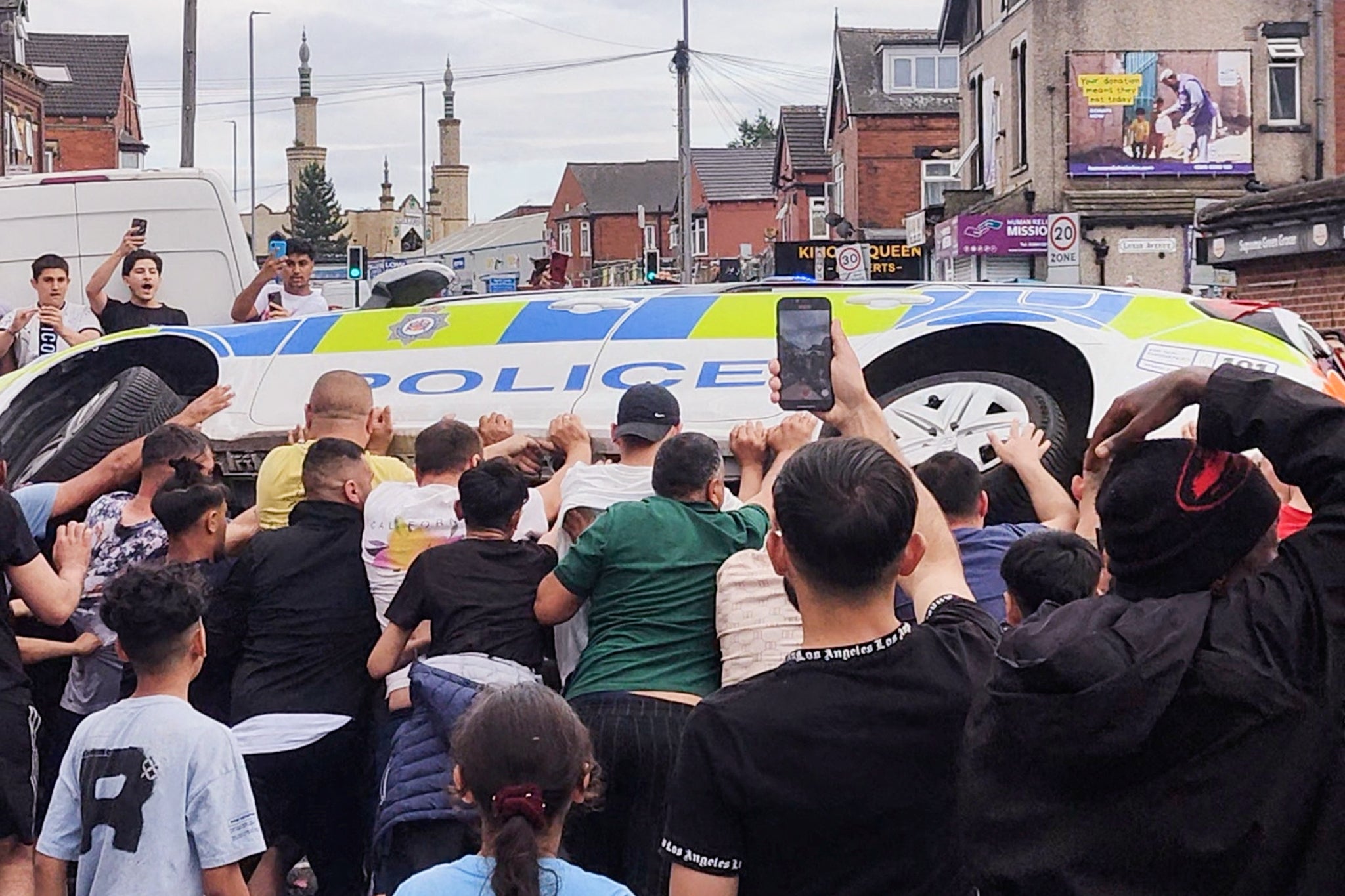 A police car is overturned during the riots