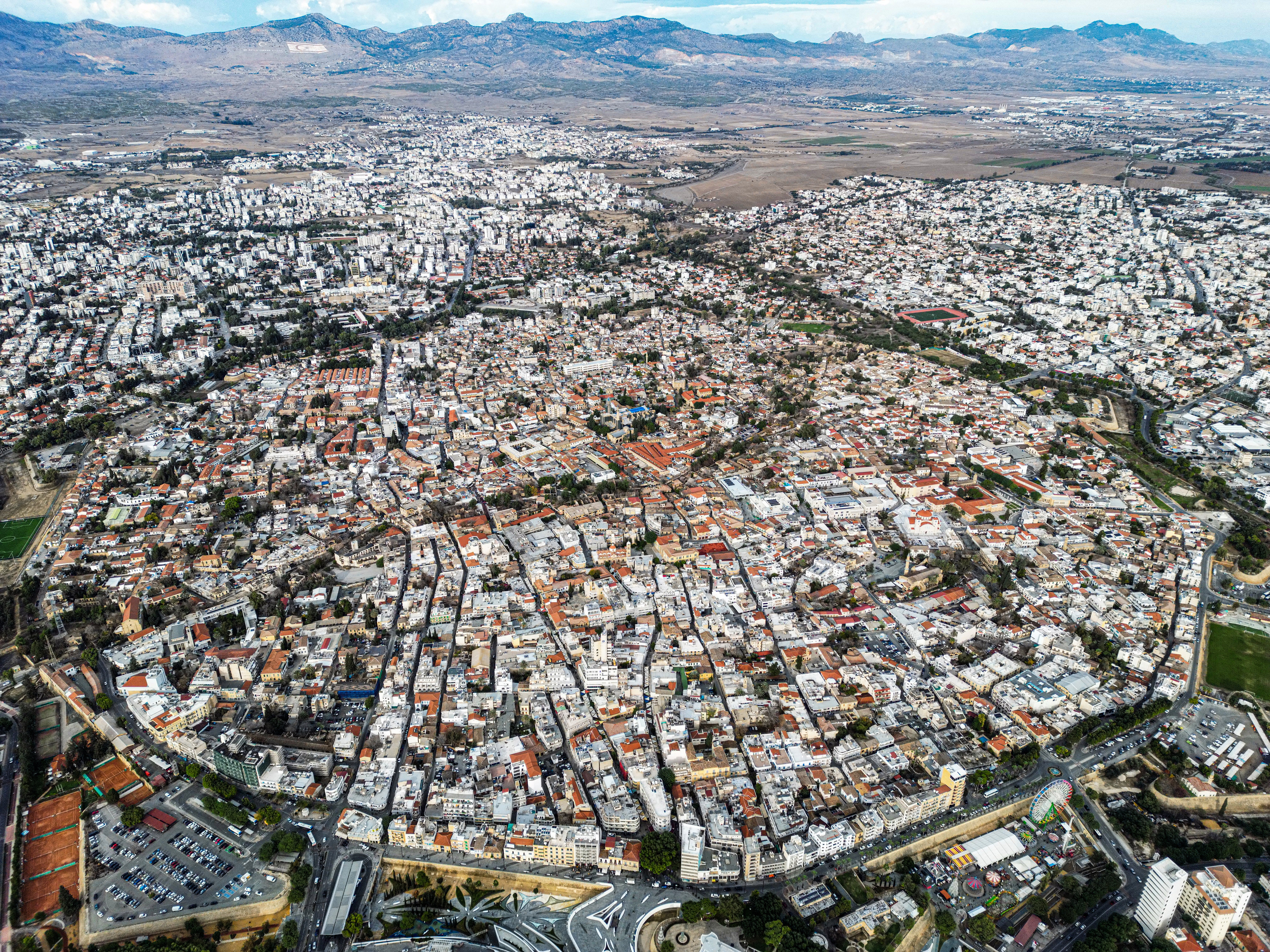 An aerial view of the divided walled city of Cyprus' capital Nicosia and the city centre in the area controlled by the Republic of Cyprus in the foreground, while the background shows the rest of Nicosia and the Kyrenia mountain range in the area under control by the self-proclaimed Turkish Republic of Northern Cyprus (TRNC)