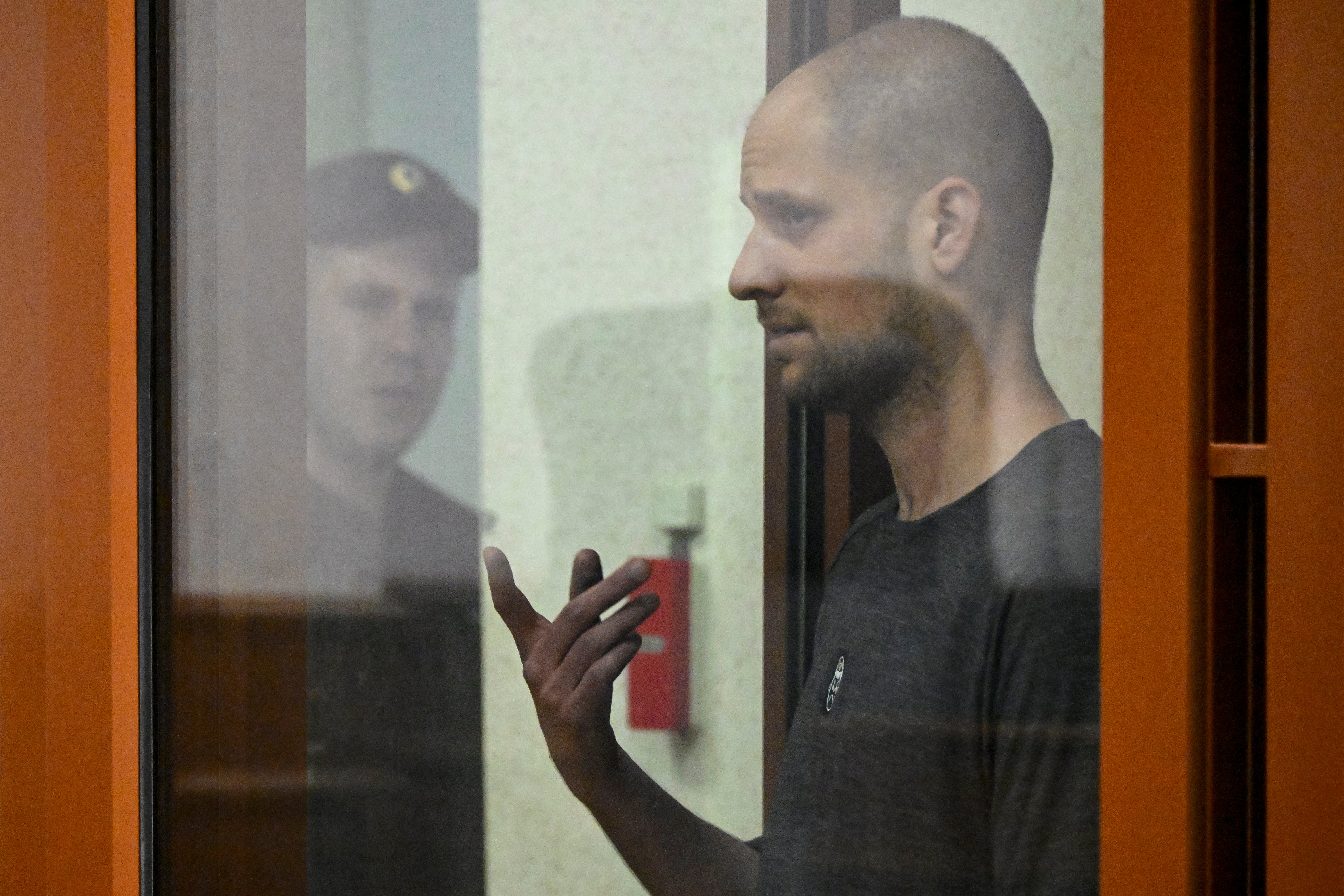 US journalist Evan Gershkovich, accused of espionage, gestures inside a glass defendants' cage during the verdict announcement at the Sverdlovsk Regional Court in Yekaterinburg on July 19