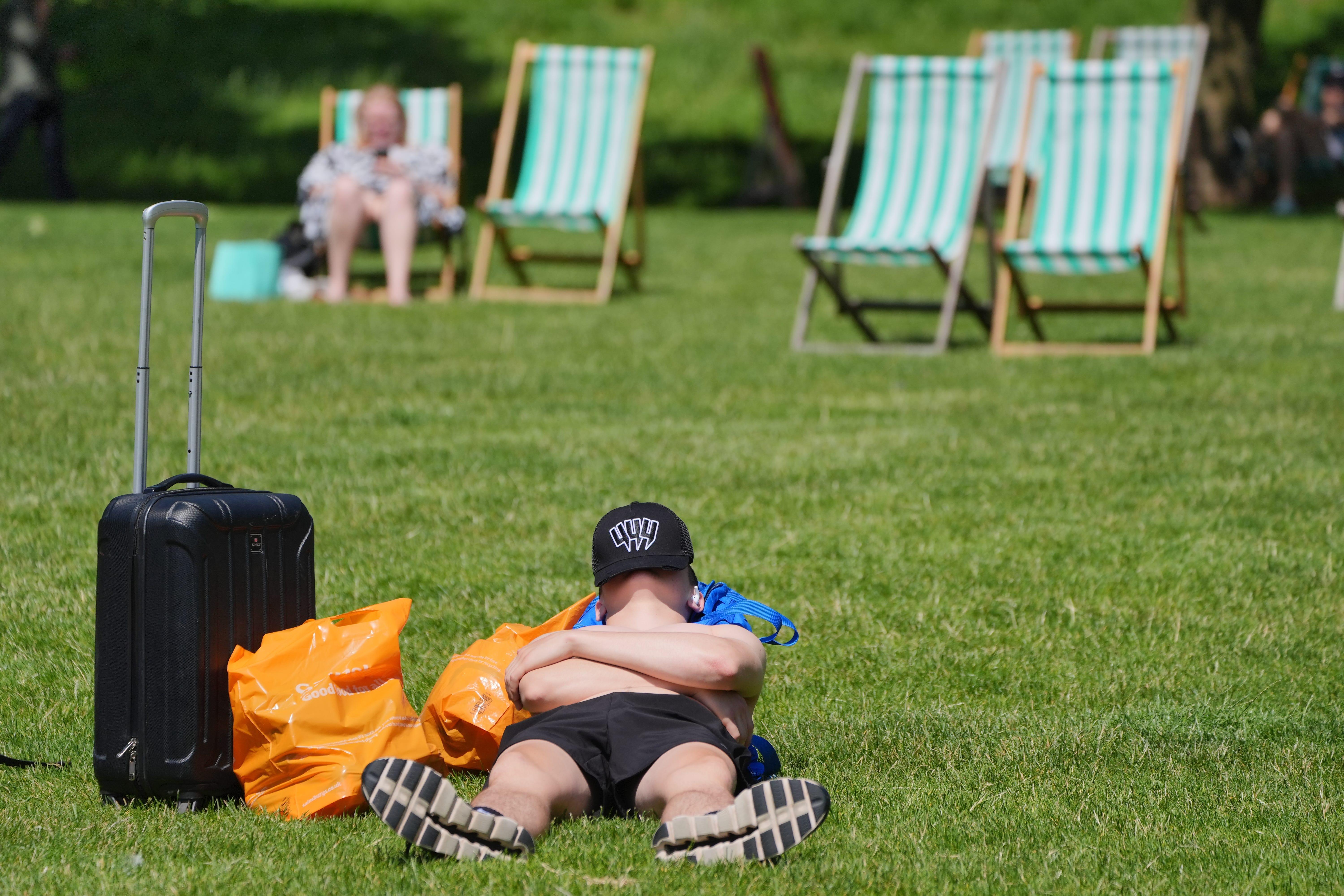 A sunbather enjoys the hot weather at Green Park in central London (PA)