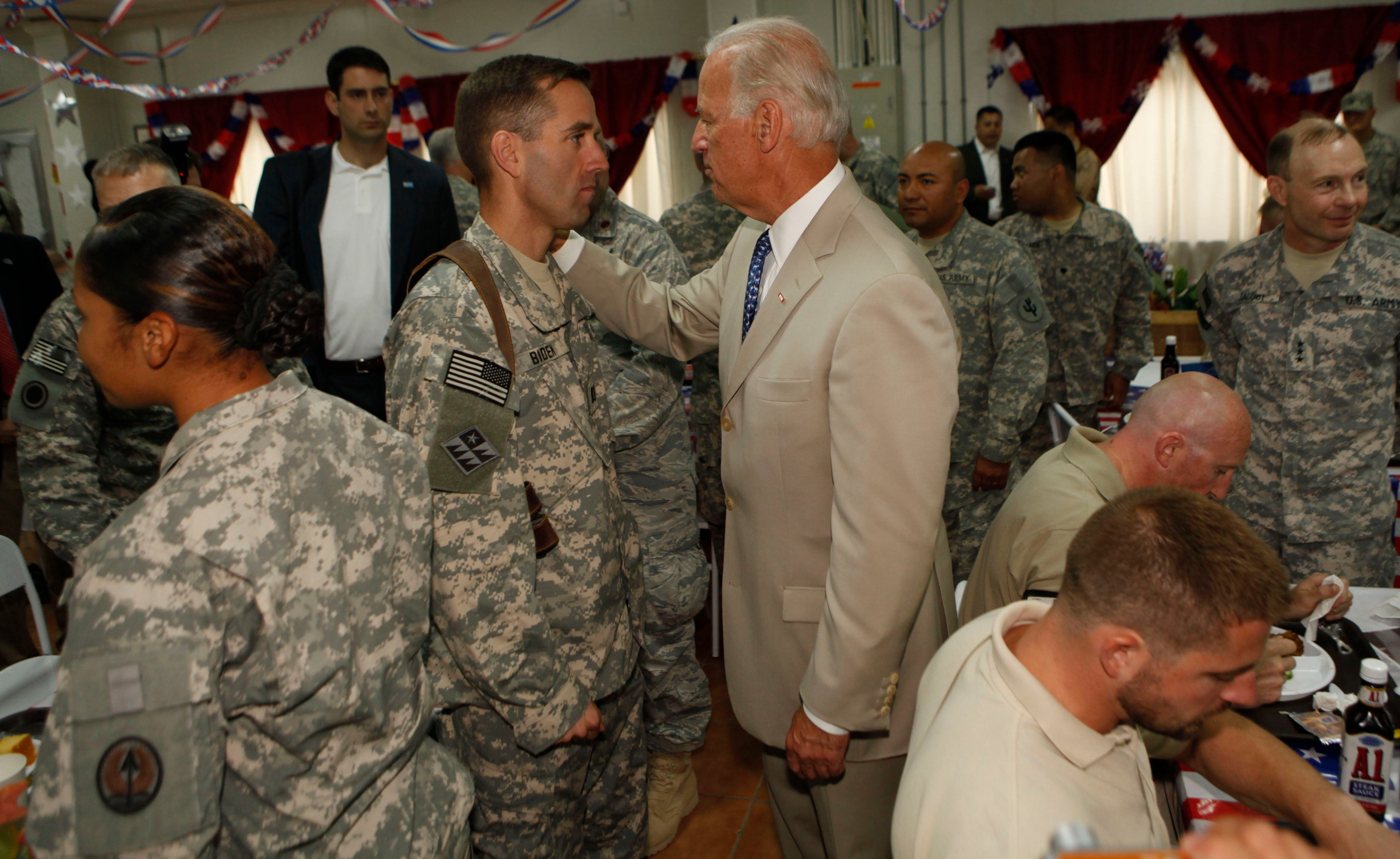 Then Vice President Joe Biden talks with his son U.S. Army Capt. Beau Biden (L) at Camp Victory on July 4, 2009 near Baghdad, Iraq — six years before Beau tragically died