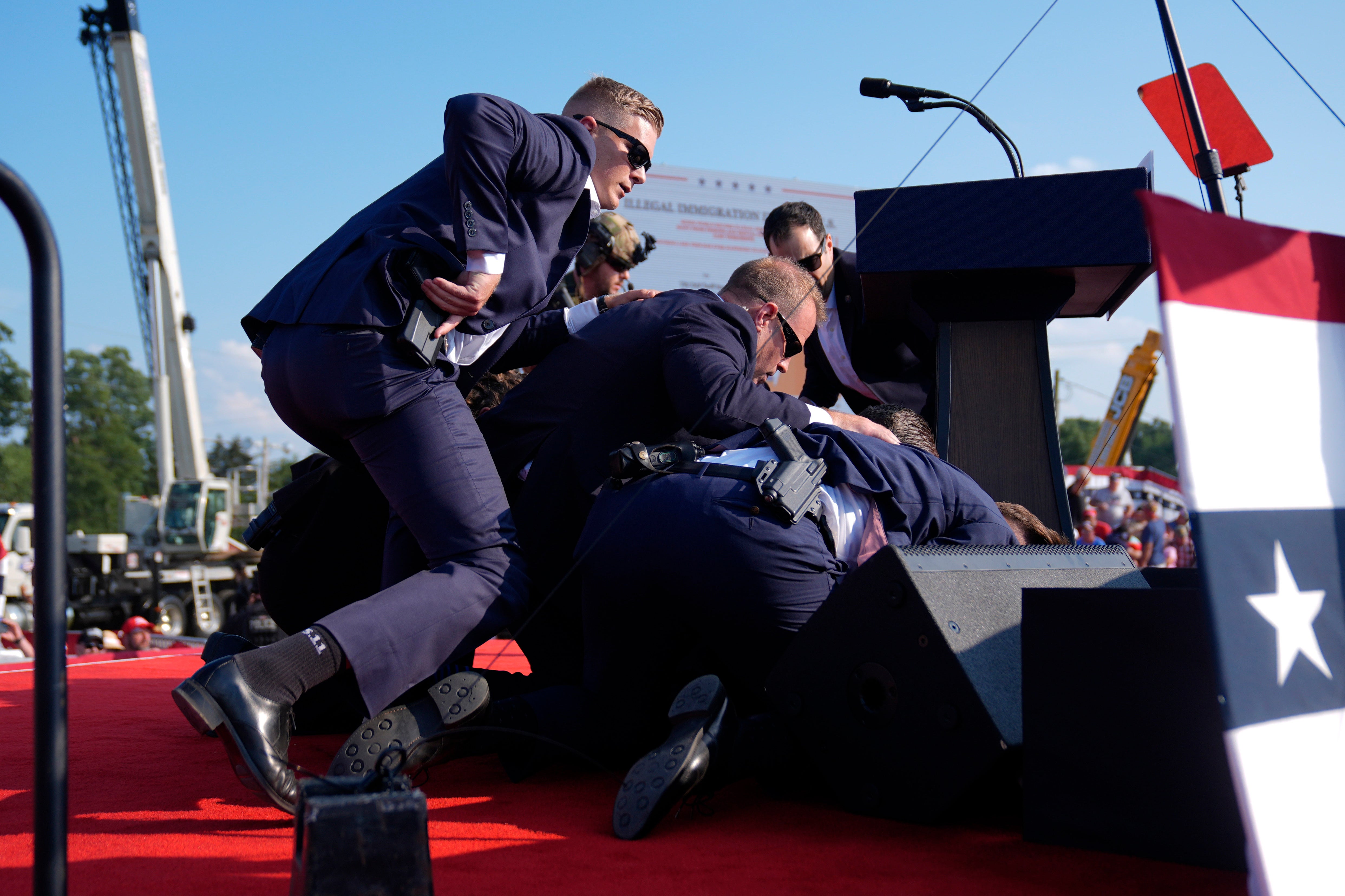 Trump is bundled to the ground after a shooter opened fire at the rally in Butler