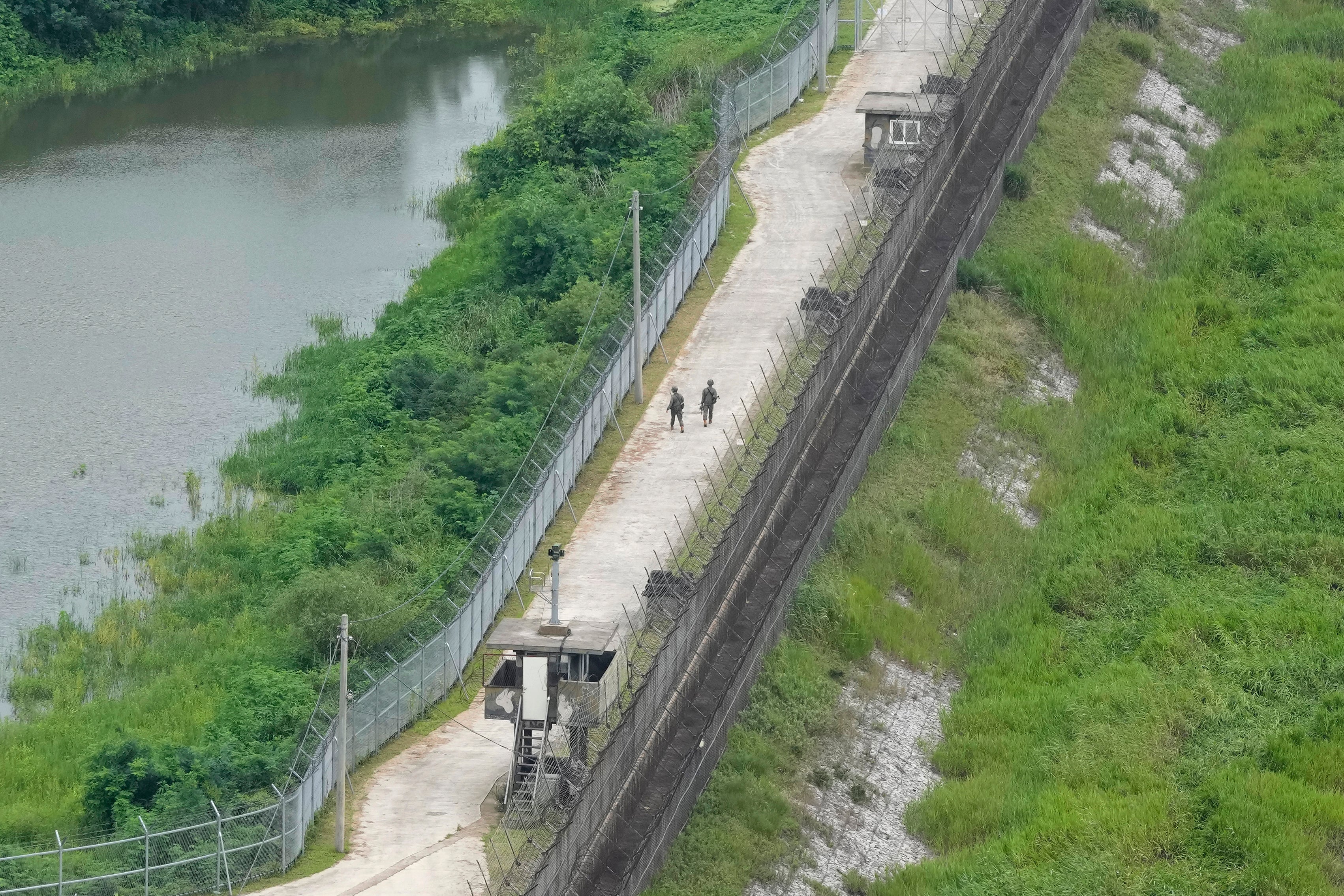 South Korean army soldiers patrol along the barbed-wire fence in Paju, South Korea, near the border with North Korea, Sunday