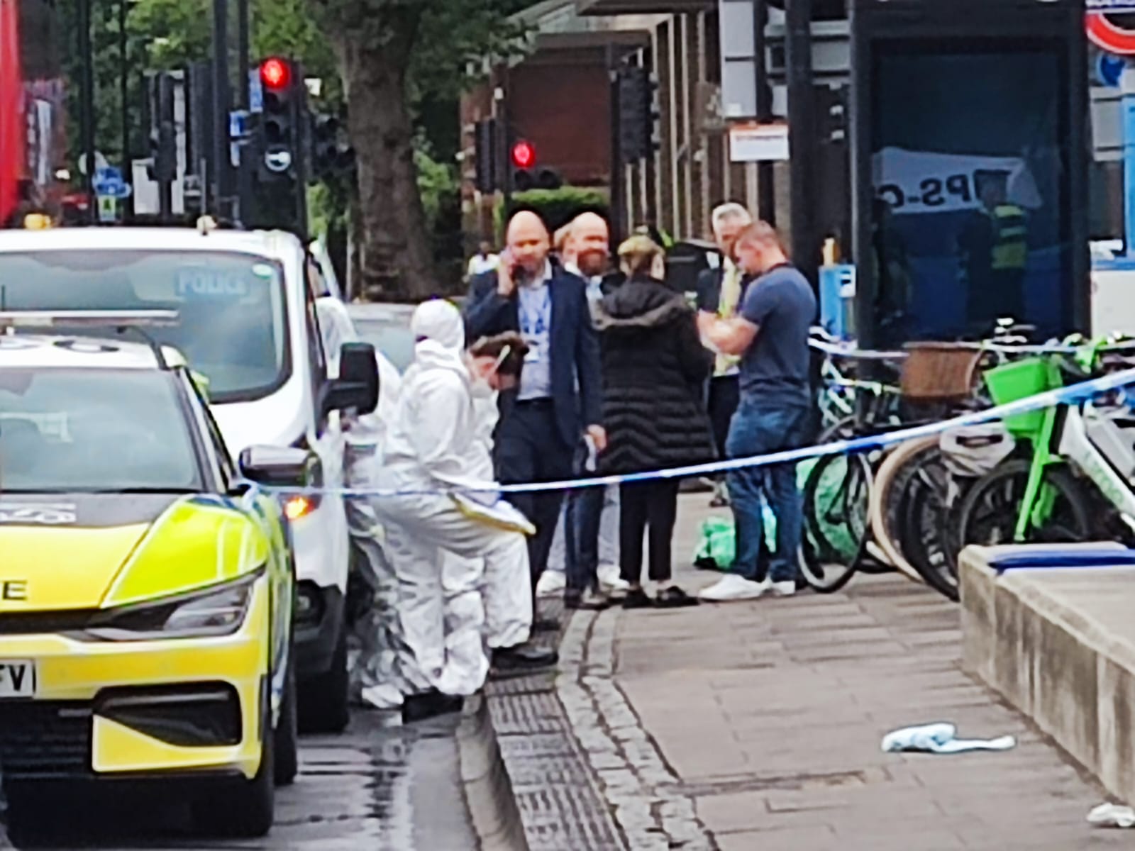 Forensics officers captured at the scene with a tent set up at the entrance of Tube station