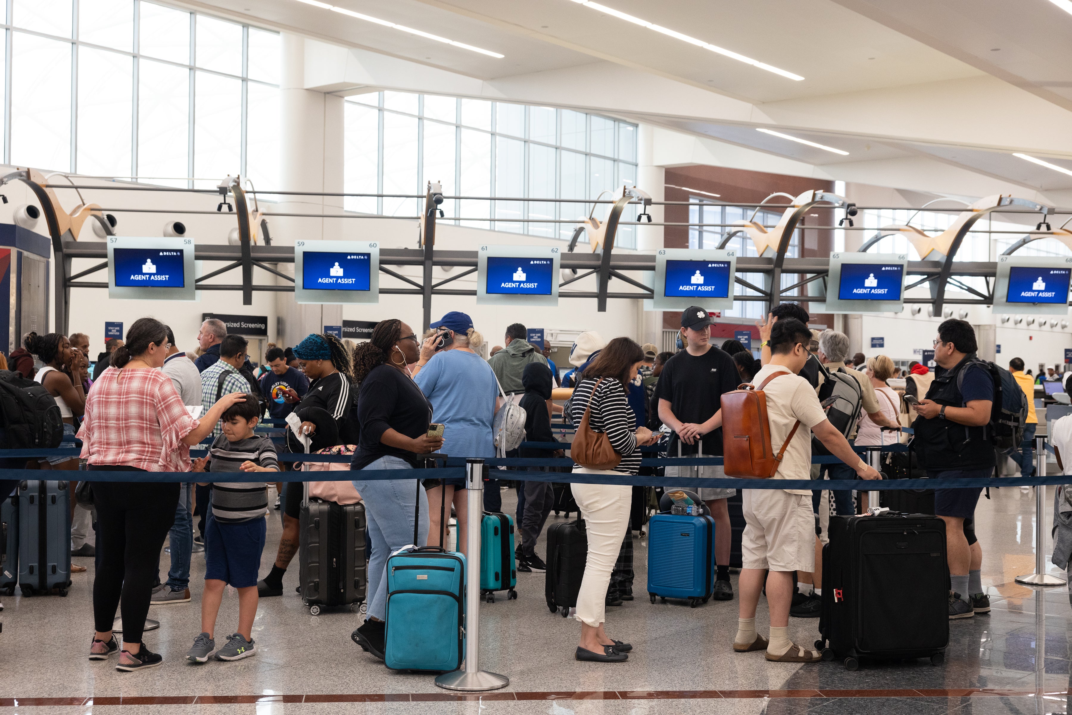 Passengers wait in line at the Hartsfield-Jackson Atlanta International Airport as Delta Air Lines experiences major delays after a worldwide IT outage