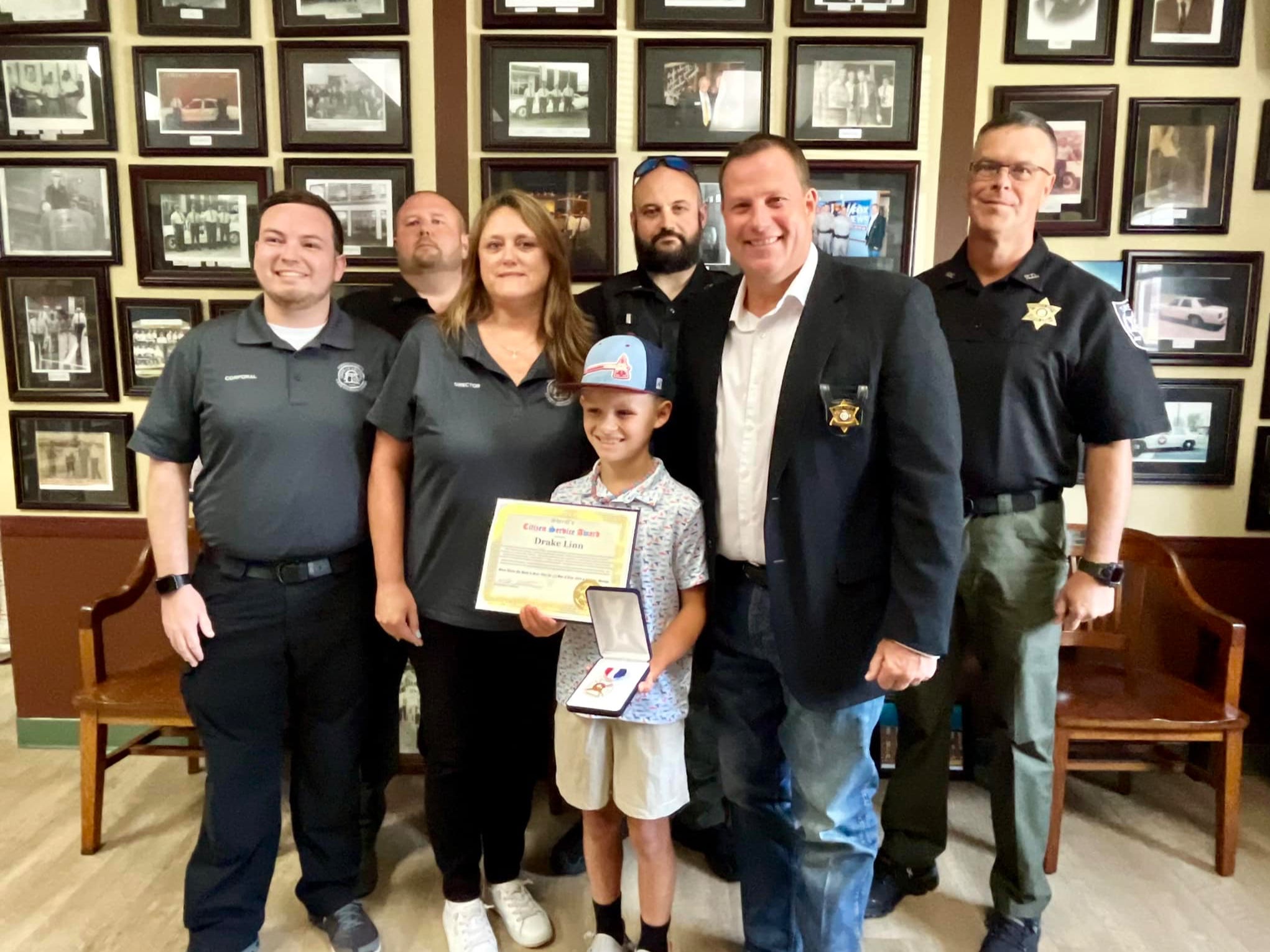 Drake Linn, 10, center, being honored by the Gordon County Sheriff’s Office in Georgia. The child saved his grandfather’s life after he went into a diabetic coma