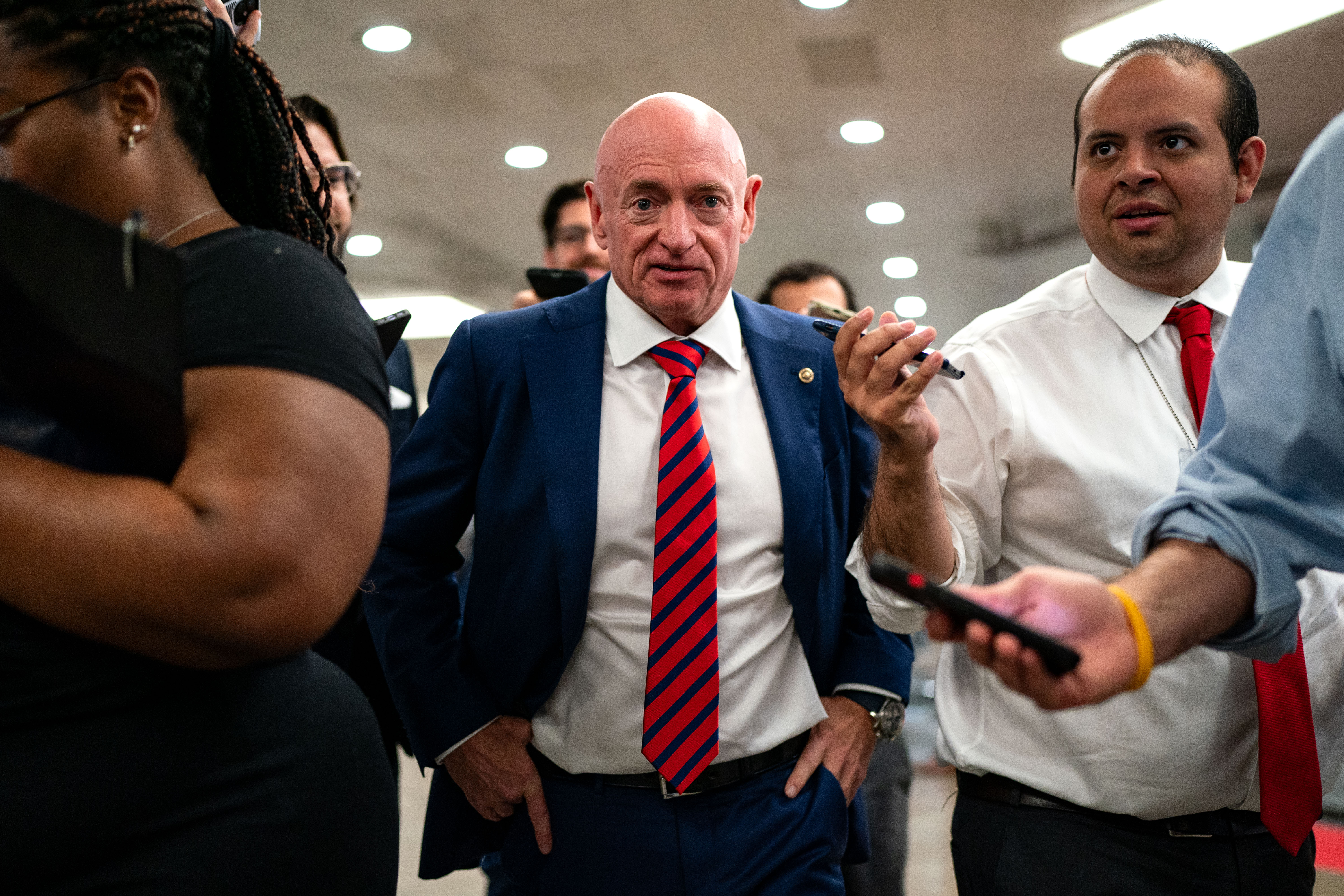 Arizona Senator Mark Kelly flanked by reporters on Capitol Hill on July 25 2024