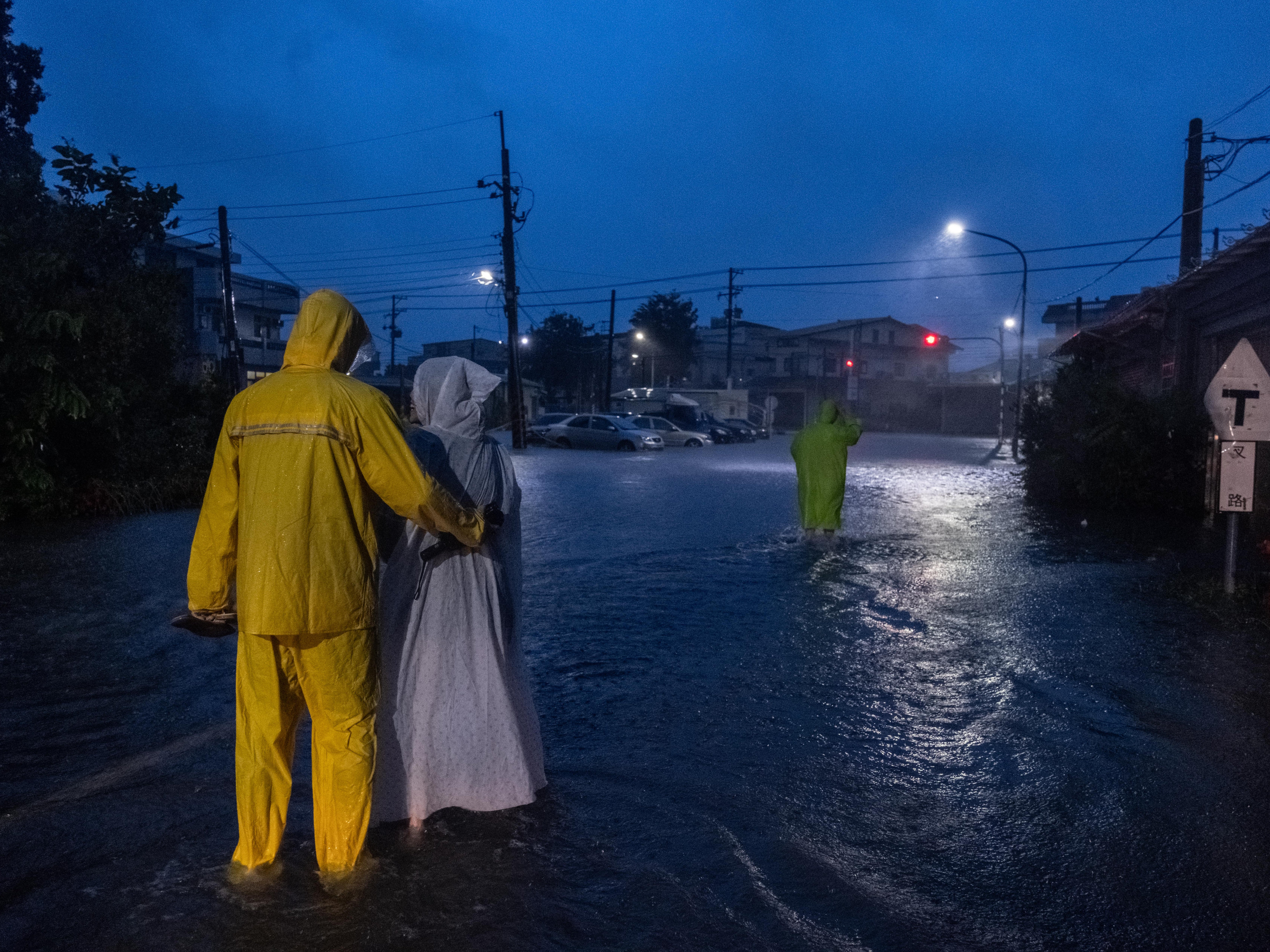 Residents walk in the flooded street in Chiayi, Taiwan