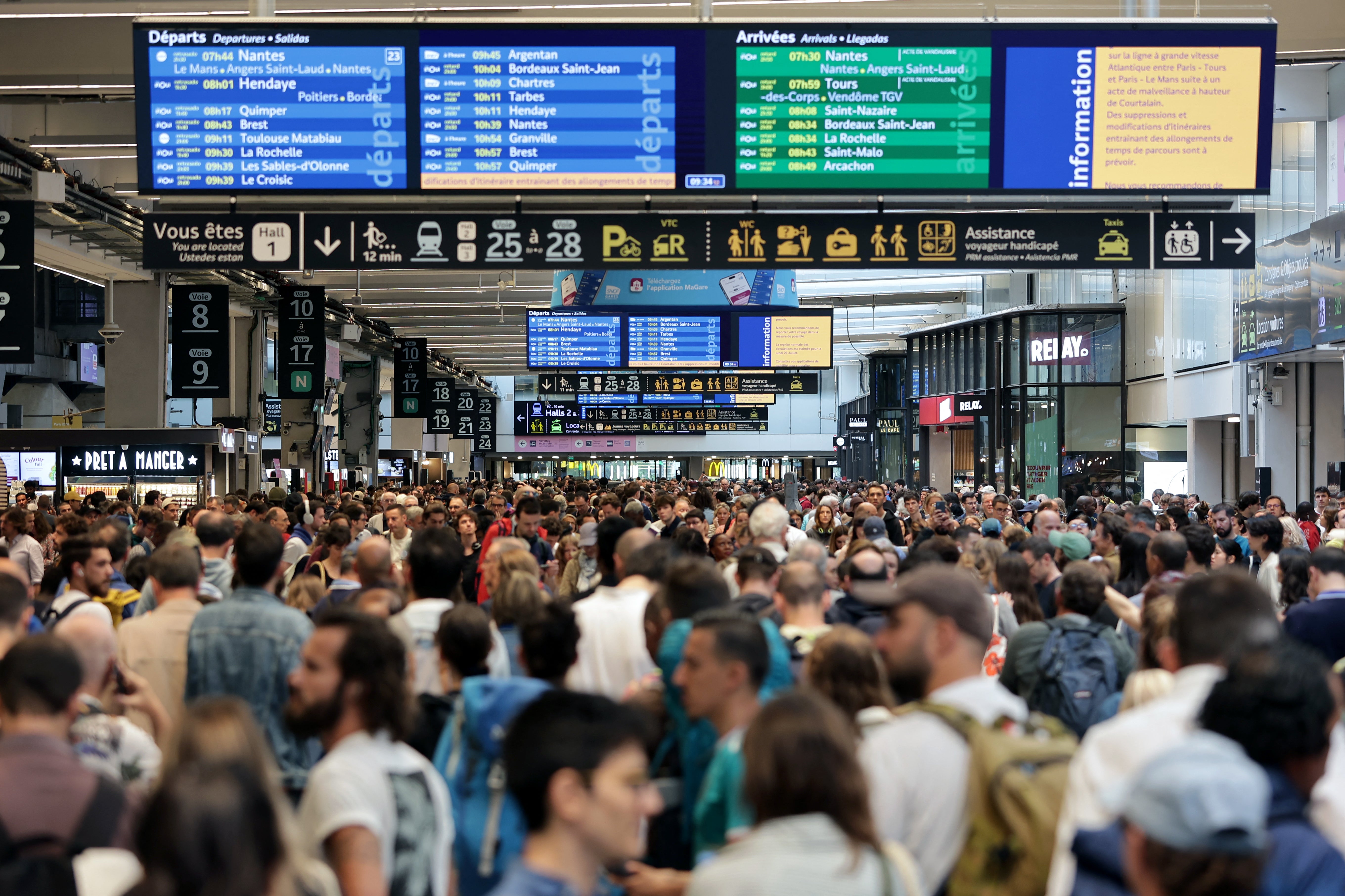 Passengers gather around the departure boards at the Gare Montparnasse station in Paris on Friday