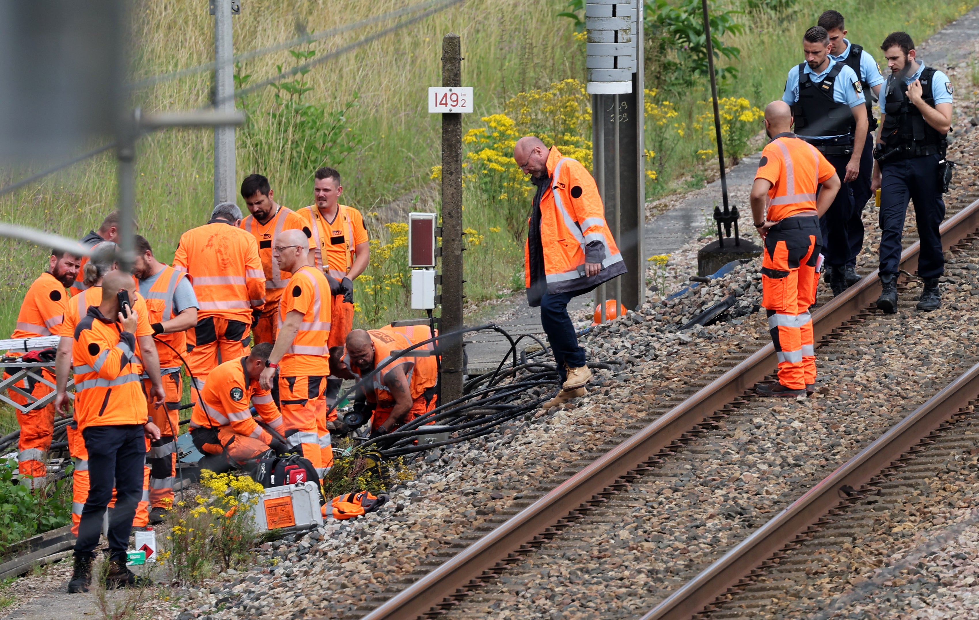 SNCF employees and gendarmes inspect the scene of a suspected attack on the high-speed railway network at Croiselles, northern France on Friday