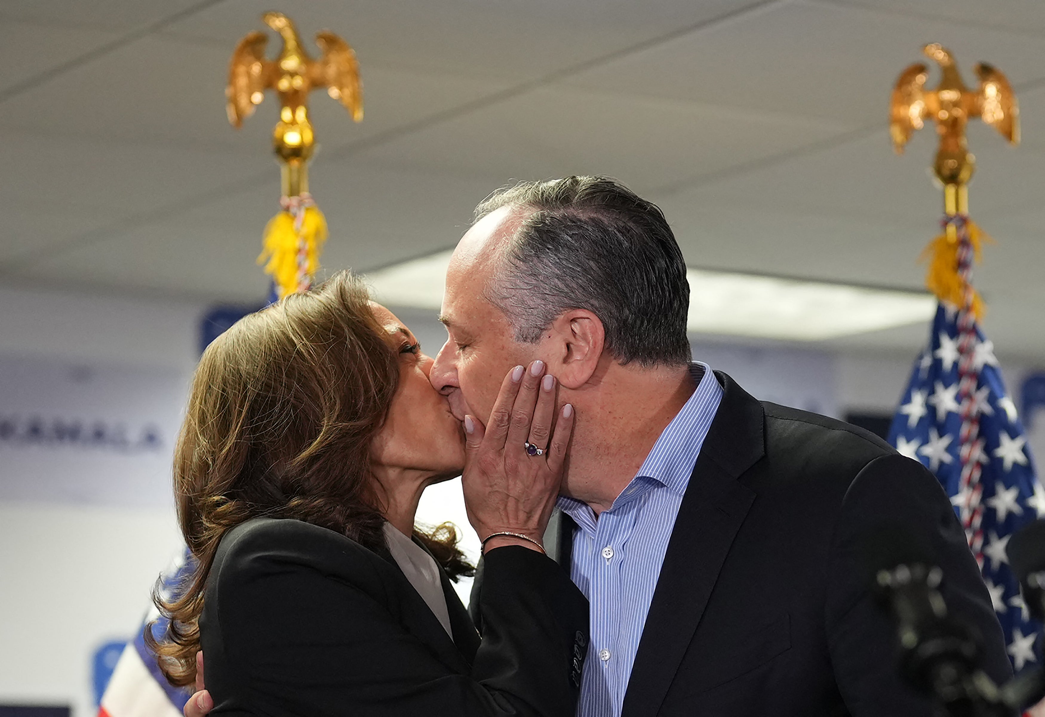 Vice President and Democratic presidential candidate Kamala Harris and Second Gentleman Doug Emhoff kiss before Harris speaks at her campaign headquarters in Wilmington, Delaware, on July 22 2024