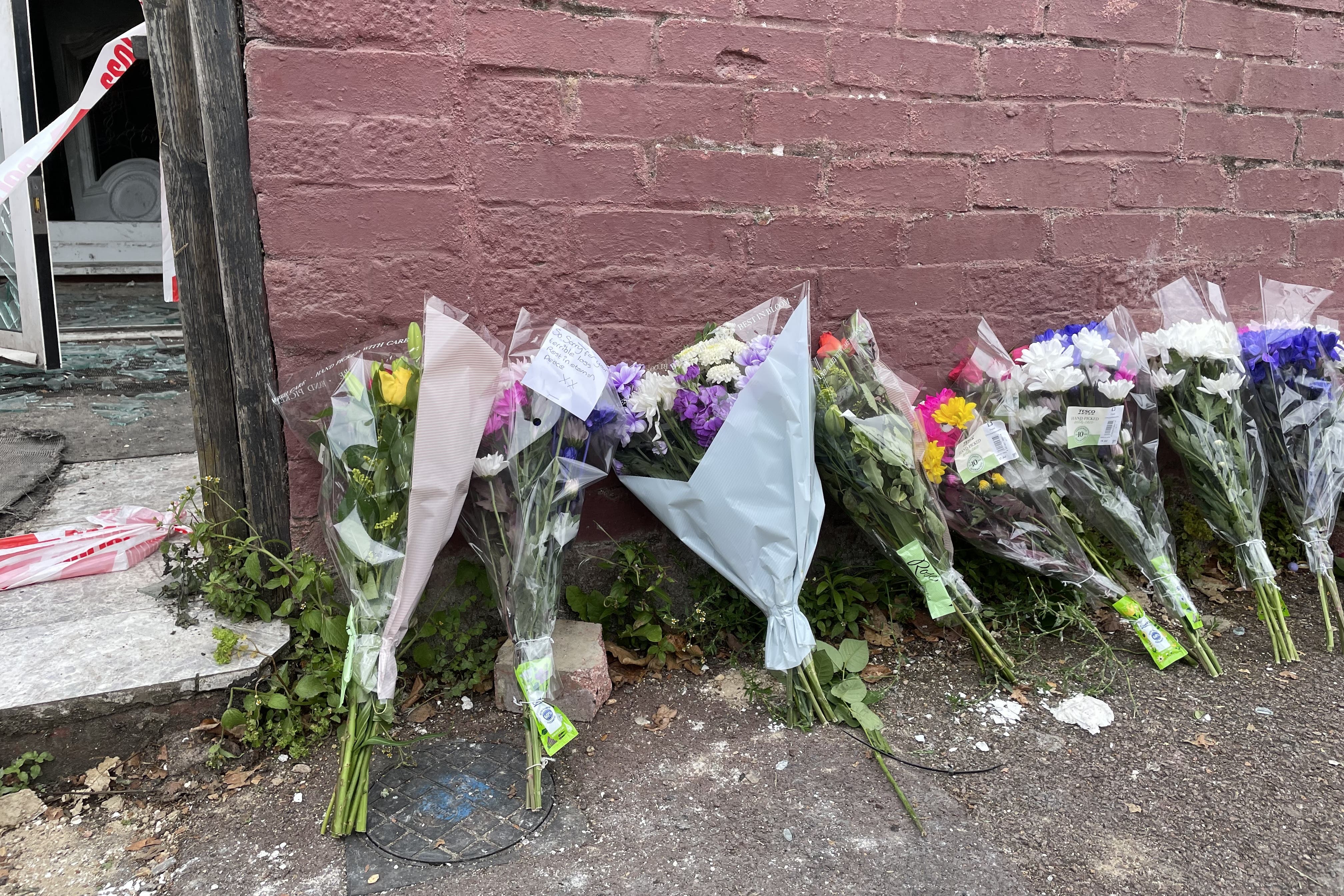 Flowers are left at the scene in Napier Road, East Ham (Rosie Shead/PA)