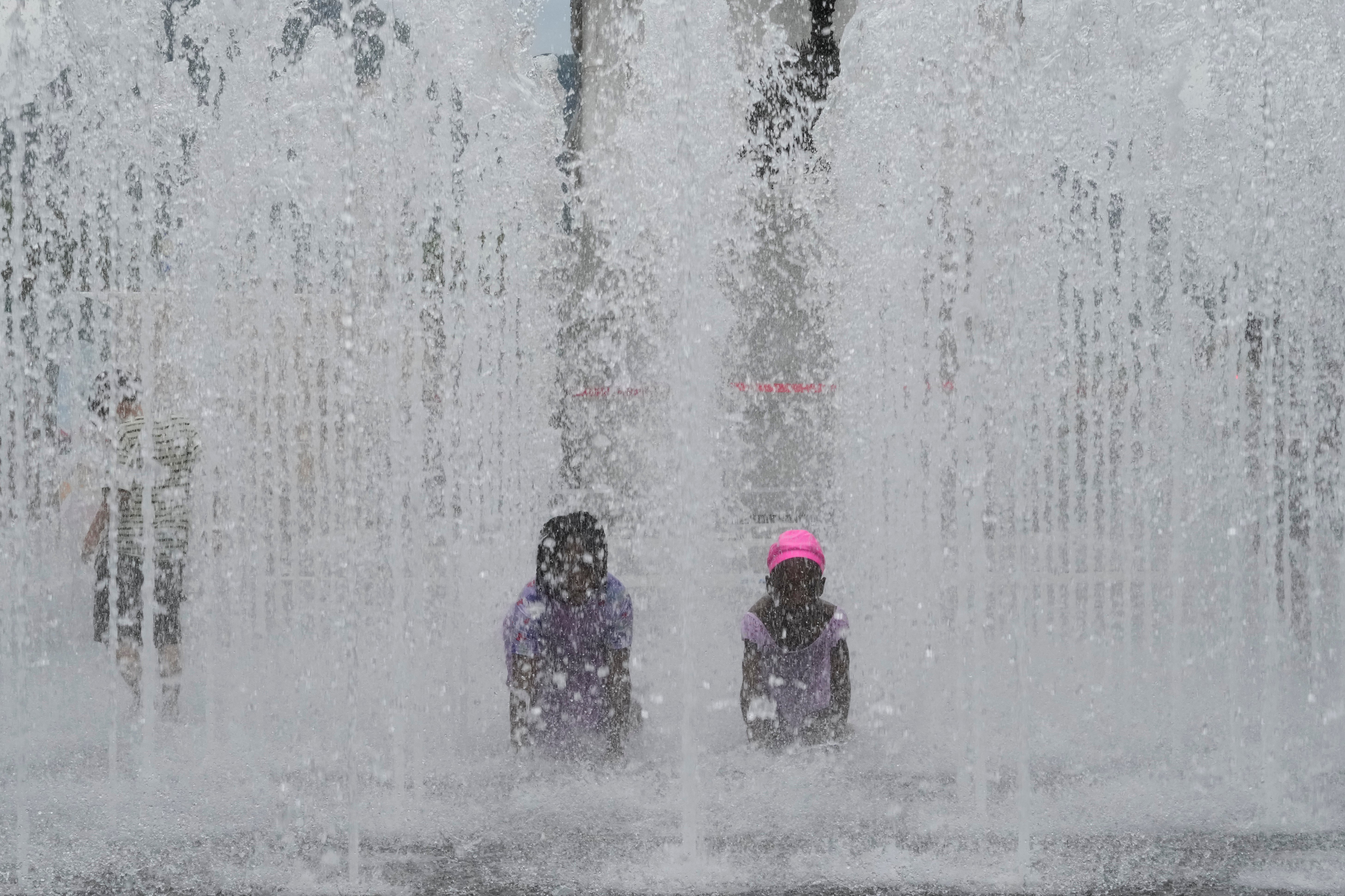 Children cool themselves off in a public fountain in Seoul, South Korea