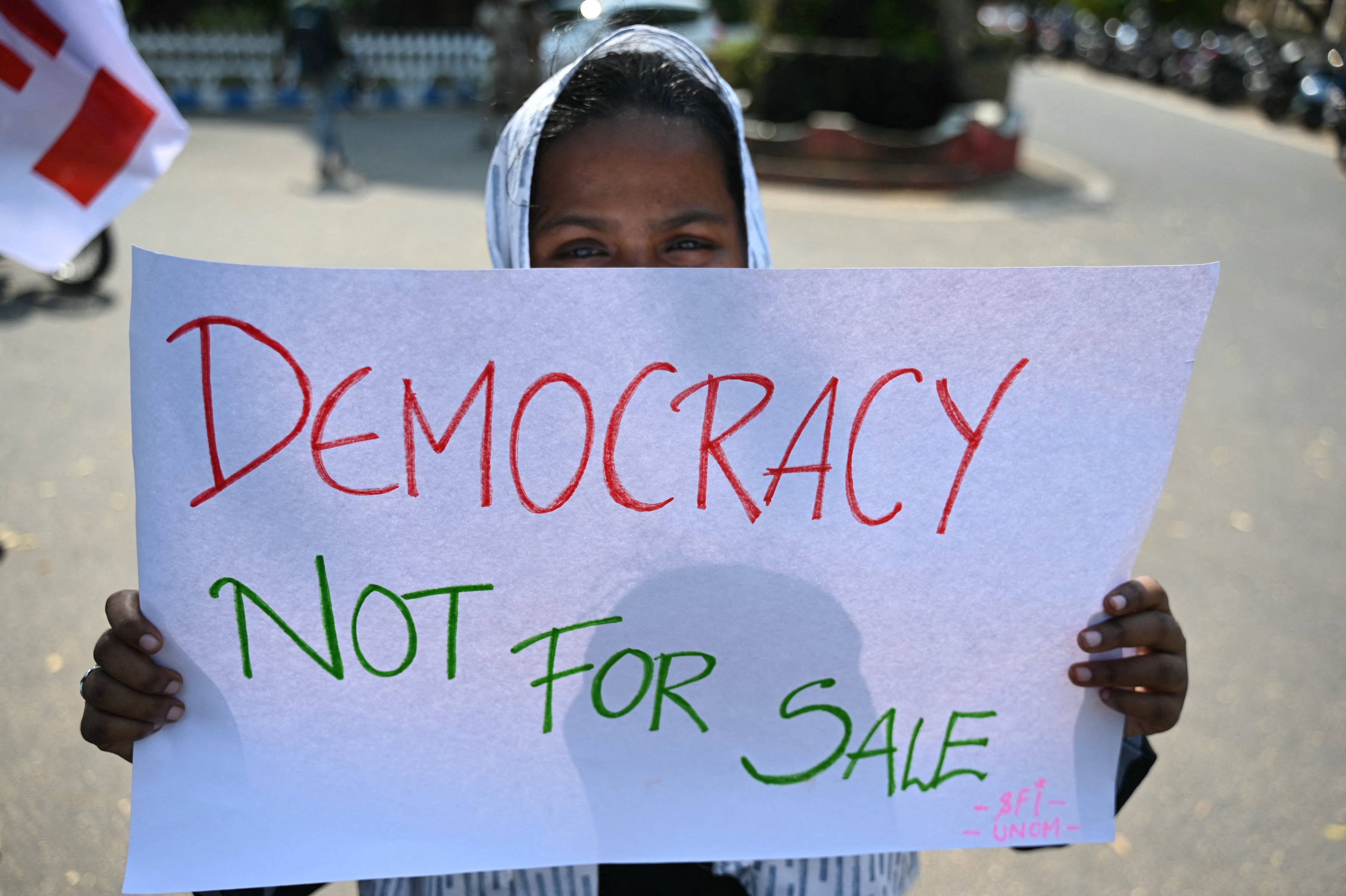 A student in India holds a placard protesting oppression